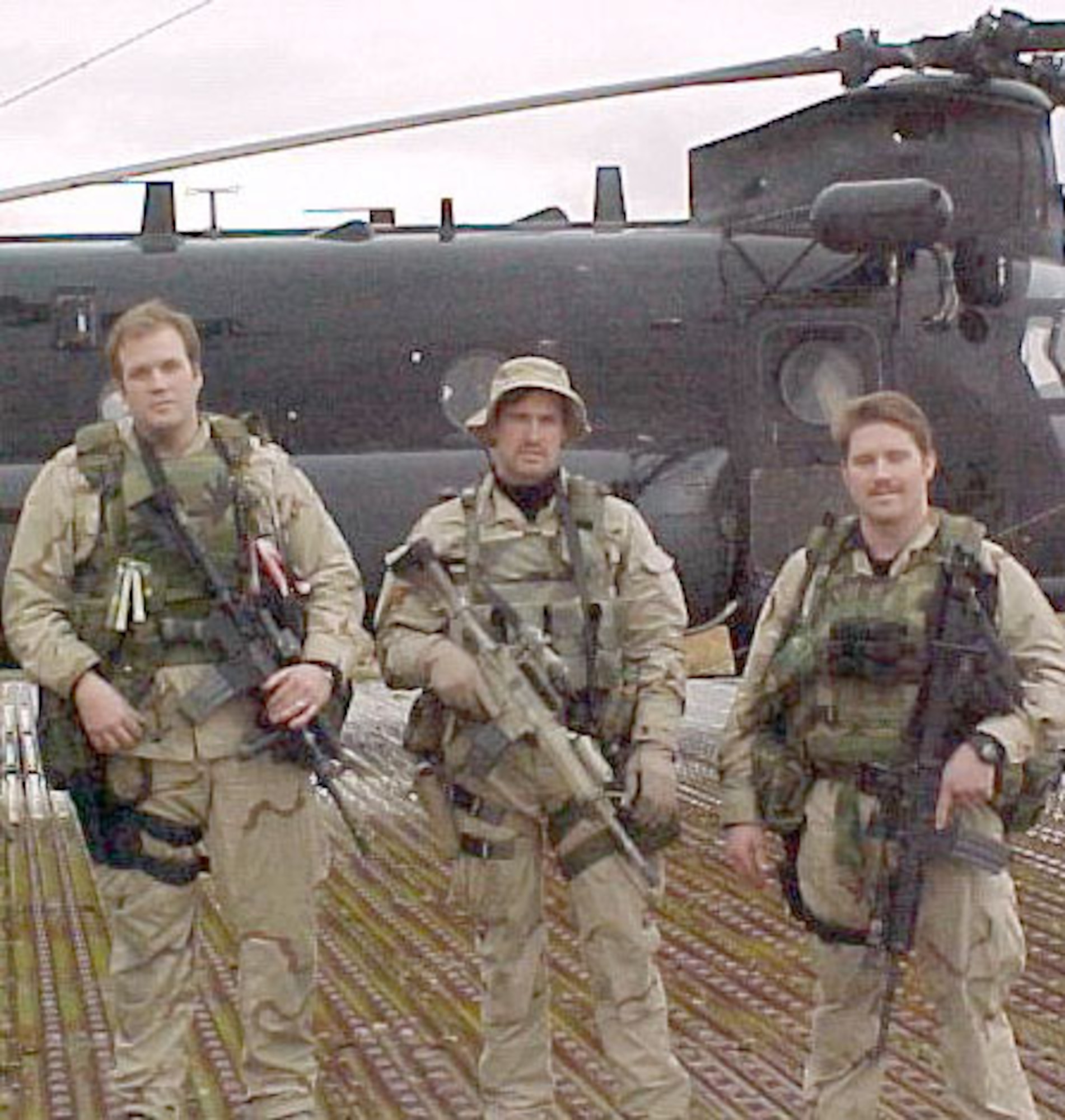 (From left to right) Tech. Sgt. Keary Miller, Senior Airman Jason Cunningham and Staff Sgt. Gabe Brown about three weeks before the battle. Behind them is a MH-47E, the same type of helicopter that took them to Takur Ghar. (U.S. Air Force photo)