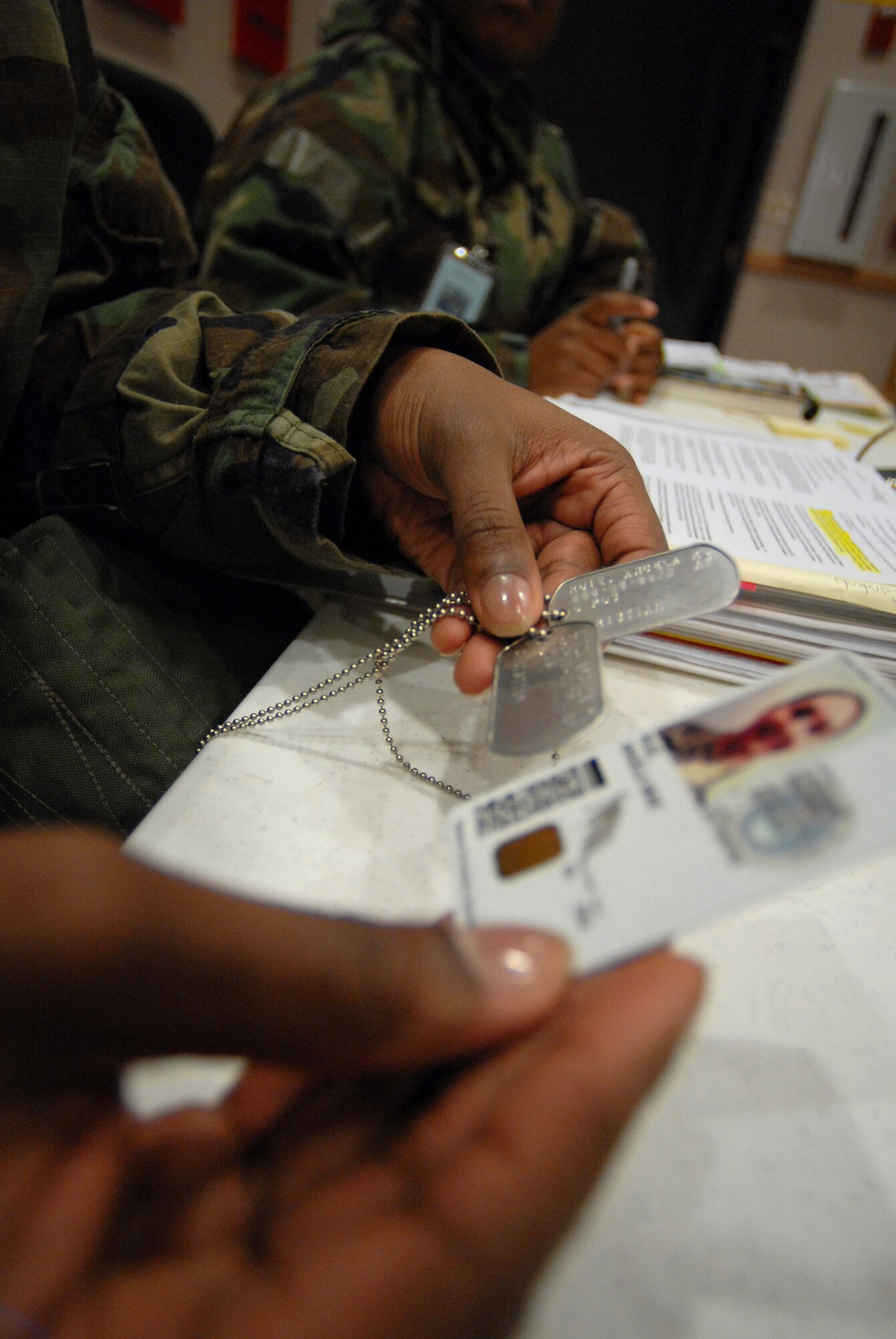 Senior Airman Shantel Langston, 8th Force Support Squadron, verifies an Airman's identification card against their "dog tags" as they process though the Personnel Deployment and Readiness Function line. Airman Langston is participating in the Peninsula-Wide Operational Readiness Exercise Beverly Bulldog 09-01 at Kunsan Air Base, Republic of Korea, Jan. 12, 2009. The PDRF Line  is a key component in accepting any follow on forces to the wolf pack. (U.S. Air Force Photo by Senior Airman Angela Ruiz)