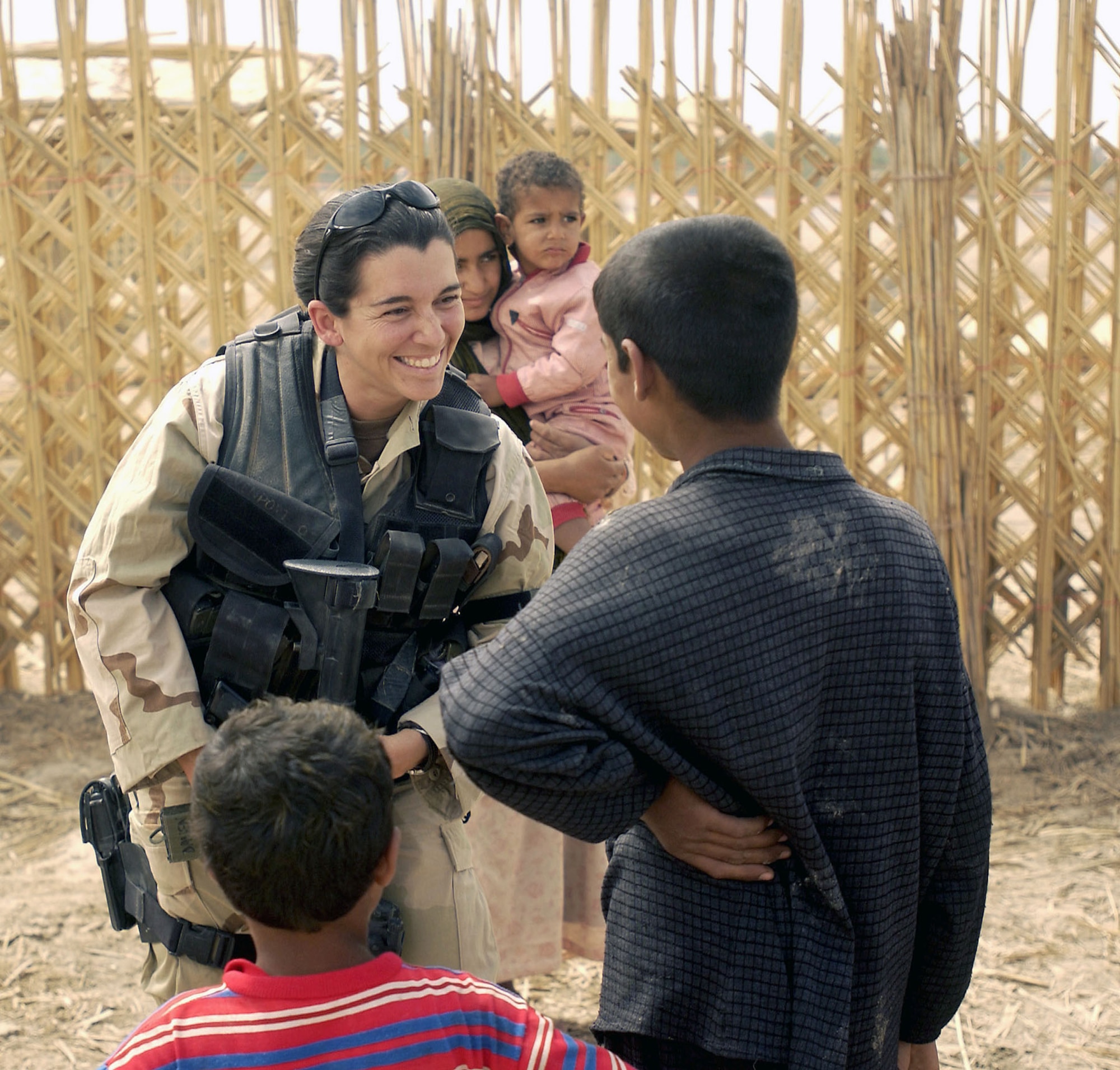 OSI agent greeting local children while on a security visit in An Nasariyah, Iraq, in May 2003. (U.S. Air Force photo)