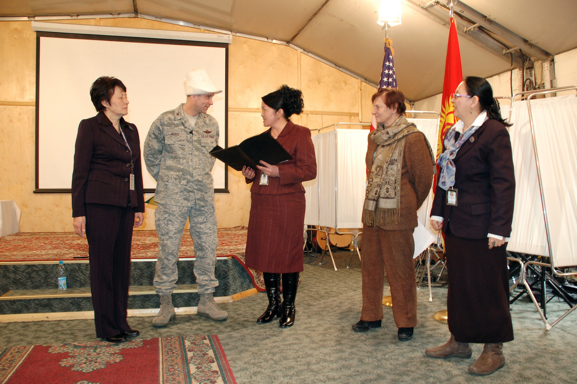 Members of the Kyrgyzstan Congress of Women present Col. Christopher Bence with a gift and a traditional Kyrgyz kalpak hat during a Jan. 8 tour of Manas Air Base, Kyrgyzstan. The group, which consisted of female civic and business leaders from throughout Kyrgyzstan, visited the base to meet with Airmen and to learn more about the mission and the contributions of women who serve there. Colonel Bence is the 376th Air Expeditionary Wing commander. (U.S. Air Force photo/Maj. Damien Pickart) 

