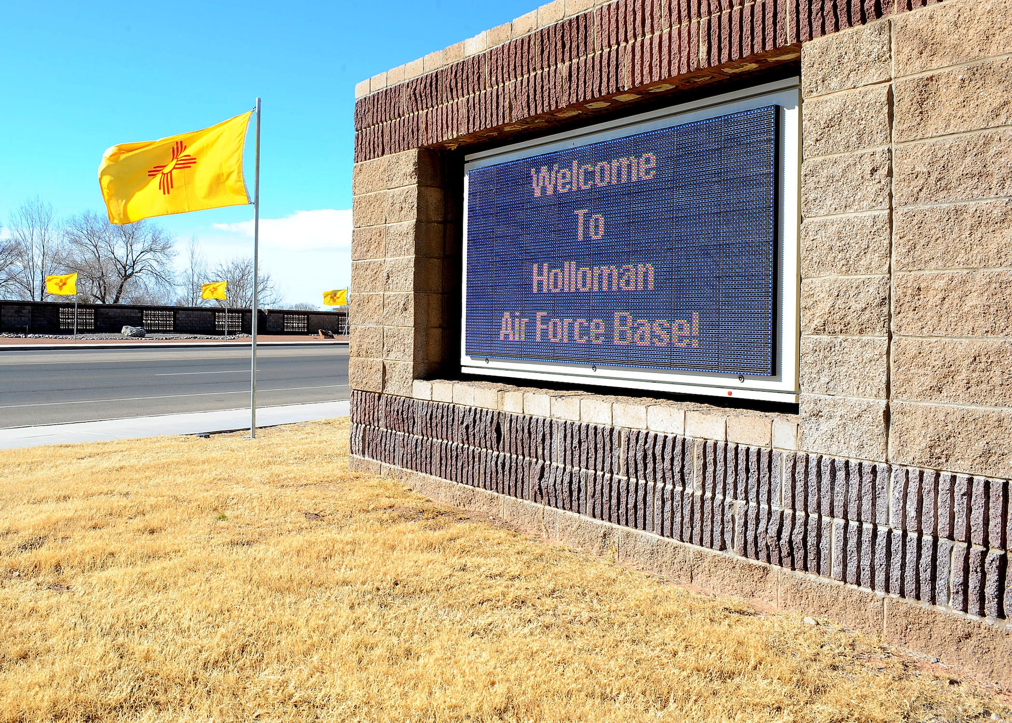The New Mexico flag waves in the breeze on Jan. 6, 2009, at the front gate of Holloman Air Force Base. The flags replaced the normal presentation of U.S. Flags, New Mexico state flags and German flags in honor of New Mexico?s admittance into the union on Jan. 6, 1912. (U.S. Air Force photo/Airman 1st Class Deandre Curtiss)
