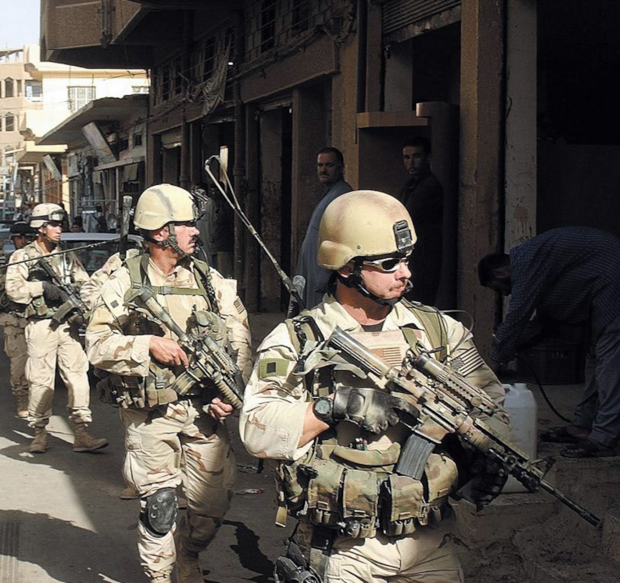 Two members of an Air Force Tactical Air Control Party accompany Army 82nd Airborne Division soldiers on a foot patrol through an arms market in Iraq. (U.S. Air Force photo)