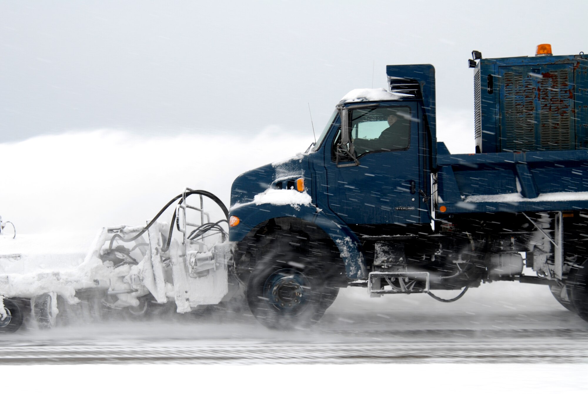 A member of the 8th Civil Engineer Squadron clears the flightline of snow and ice during the Peninsula Wide Operation Readiness Exercise at Kunsan Air Base, Republic of Korea, Jan. 12, 2009. A snow storm dumped more than 10 inches of snow on Kunsan, allowing only emergency and mission essential vehicles to move around base. (U.S. Air Force Photo by SSgt Jason Colbert)