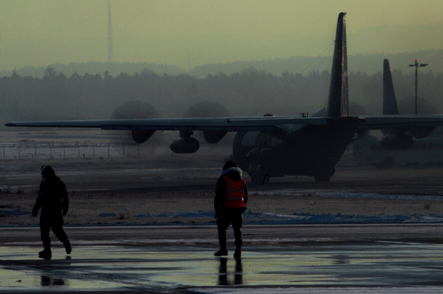 Airmen with the 86th Maintenance Squadron walk back to hanger two after marshalling a C-130 to take off for the day's mission at Ramstein Air Base Jan. 9, 2009. (U.S. Air Force photo by Airman 1st Class Kenny Holston)