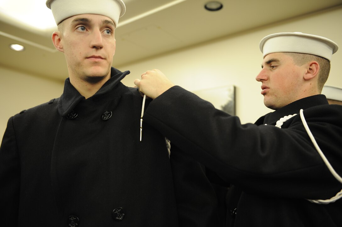 U.S. Navy Seaman Recruit Casey Chadwick, left, and Seaman Recruit Seth Taylor, both members of the honor guard, make final touches to their uniforms at the U.S. Capitol for the rehearsal of the 56th Presidential Inauguration in Washington, D.C., Jan. 11, 2009.
