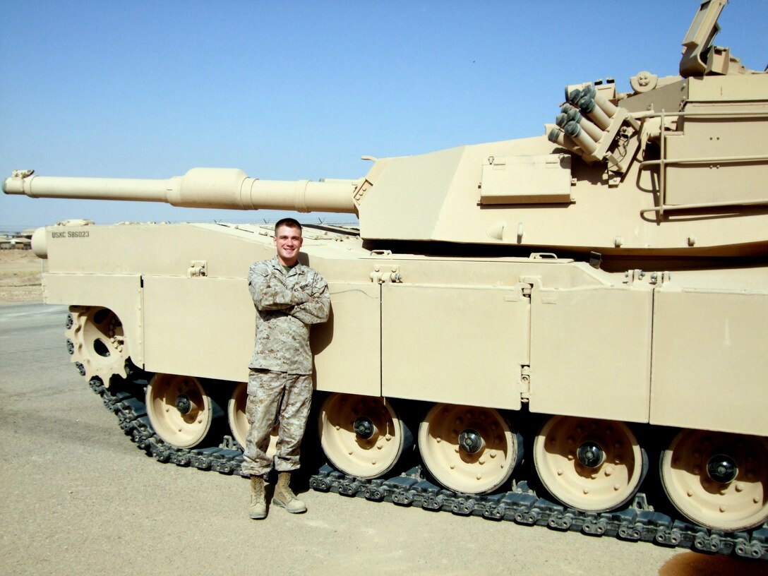 Corporal Jacob McDonald, the noncommissioned officer in-charge of the Fleet Support Division's weapons warehouse on the Yermo Annex, stands next to an M1A1 Abrams Tank in Al'Taqqadum, Iraq. McDonald deployed to Iraq in 2009 as an individual augmentee.