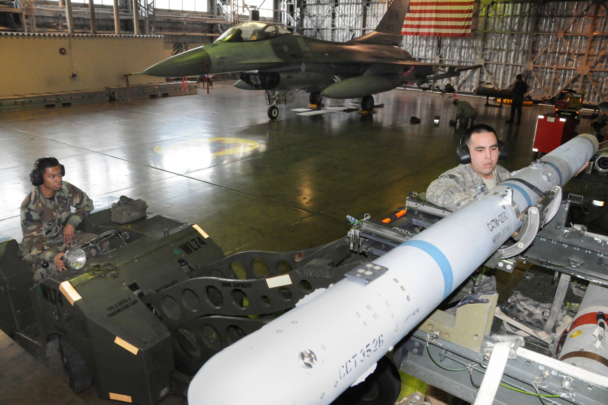 MISAWA AIR BASE, Japan -- Airman 1st Class Lauron Turner and Staff Sgt. Jack Holmes, both of the 35th Aircraft Maintenance Squadron, prepare to load an AIM-120 advanced medium range air-to-aim missle by using an MJ-1 lift truck Jan. 9, 2009. The MJ-1, also called a "jammer," is used to load and unload a wide variety of munitons and has a lifting capacity of 3,000 pounds. (U.S. Air Force photo by Senior Airman Jamal D. Sutter)