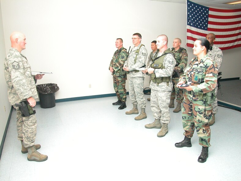 Master Sgt. Jeff Dennis, swing shift flight chief, passes information to members of his flight at guardmount, a typical gathering for Security Forces members just before shift changes. Selected members provide briefings on subjects such as weapons safety, use of force, operations security and communications security. (U.S. Air Force photo by SSgt Joe Davidson)