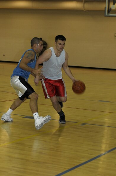 MINOT AIR FORCE BASE, N.D. – 1st Lt. Peter Smith, a member of the 91st Operations Group intramural basketball team,  drives past  Staff Sgt.  Joshua Hobson, a member of the 91st Maintenance Group team, during the 2008-09 Intramural Basketball Championship game held at the McAdoo Fitness Center here Jan. 12.  The 91st OG took home the championship after defeating the 91st Maintenance Group 49-28. (U.S. Air Force photo by Tech. Sgt. Lee A. Osberry Jr.)