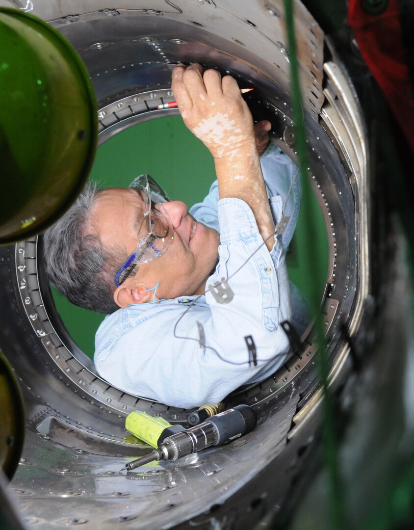 Juan Ortiz, Lear Siegler Inc. contractor, works to remove and replace the aft fuselage ejector rings on a T-38 at the Queen Bee facility at Randolph Air Force Base, TX. Queen Bee is the only heavy maintenance provider for the T-38 fleet, providing support of T-38 inspection, maintenance and modification requirments continuously for more than 30 years. (US Air Force photo by Rich McFadden) 