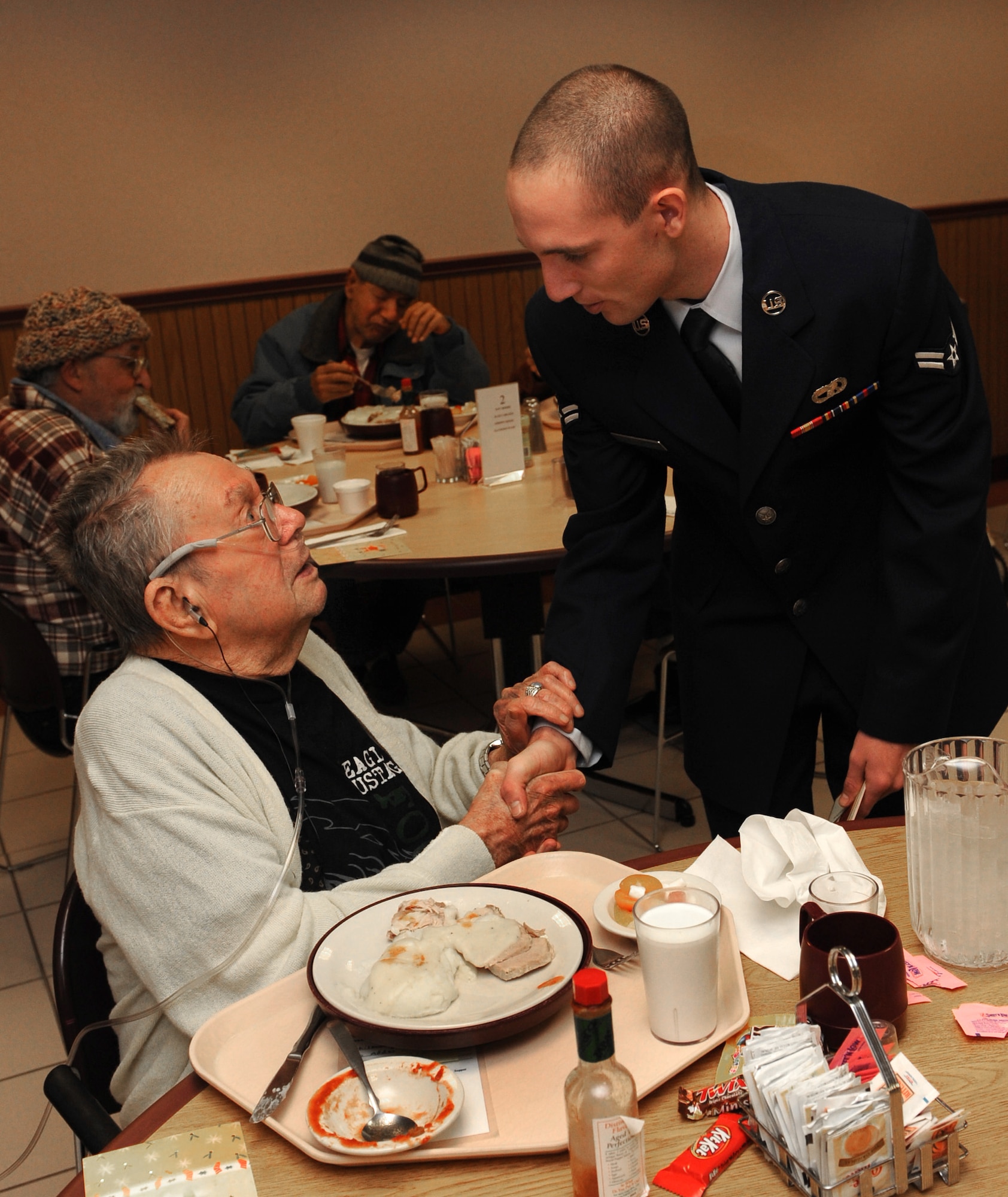 MOUNTAIN HOME AIR FORCE BASE, Idaho -- Airman 1st Class Logan Jenkins, 366th Logistics Readiness Squadron vehicle operator, shakes hands with veteran Bob Whiteman at the Idaho State Veteran's Home Dec. 16. Airmen from Mountain Home Air Force Base traveled to the Idaho State Veteran's Home in Boise for a holiday visit. The group, Airmen for American Veterans, began the day inviting veterans to bingo, after which they helped serve lunch. (U.S. Air Force photo/ Airman 1st Class Debbie Lockhart)