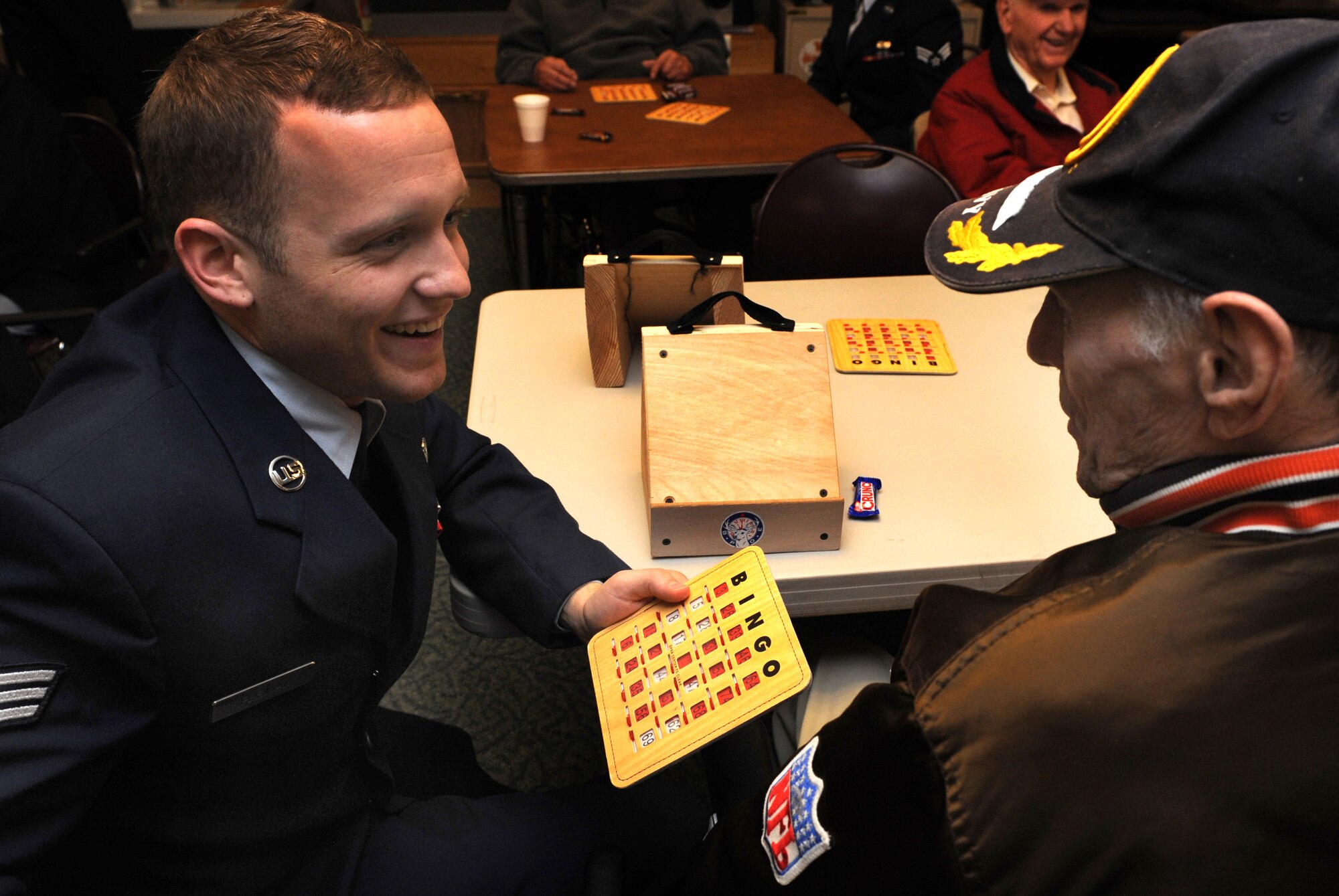 MOUNTAIN HOME AIR FORCE BASE, Idaho -- Senior Airman Paul Pleiman, 366th Logistics Readiness Squadron vehicle operator, calls out a bingo with veteran Chuck Puntney at the Idaho State Veteran's Home Dec. 16. Airmen from Mountain Home Air Force Base traveled to the Idaho State Veteran’s Home in Boise for a holiday visit. The group, Airmen for American Veterans, began the day inviting veterans to bingo, after which they helped serve lunch. (U.S. Air Force photo/ Airman 1st Class Debbie Lockhart)