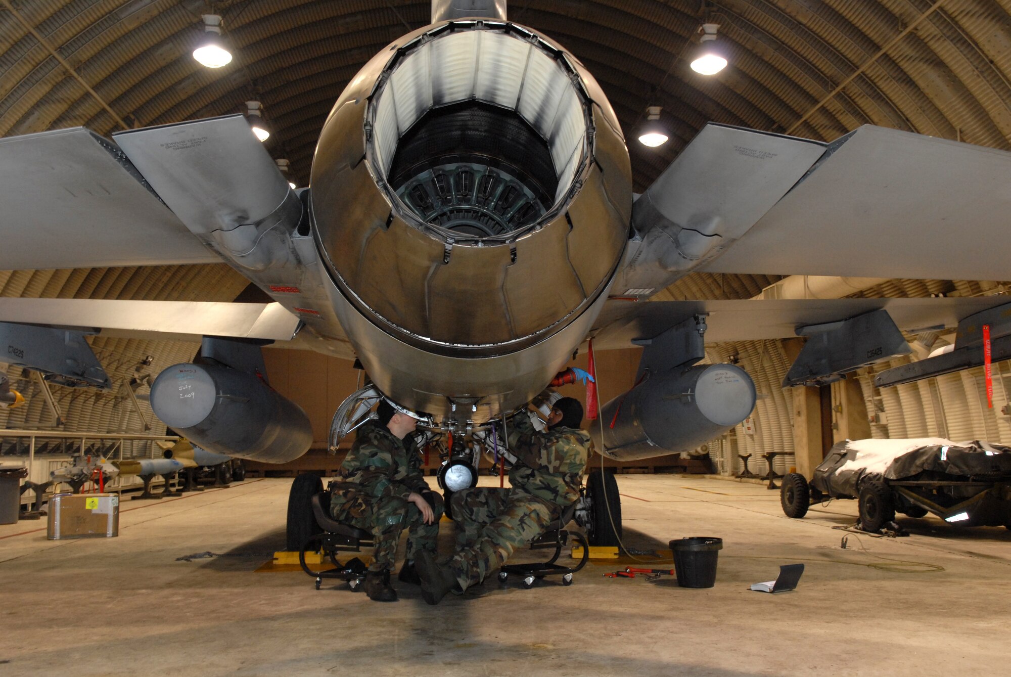 Staff Sgt. Clint Cloonan, 80th Aircraft Maintenance Unit works inside a Hardened Aircraft Shelter with Senior Airman Mark Robinson 80th AMU to remove and replace a control unit on an F-16 during the Peninsula-Wide Operational Readiness Exercise Beverly Bulldog 09-01 at Kunsan Air Base, Republic of Korea, Jan. 13, 2009. The Airmen work inside a HAS to protect them and the aircraft from enemy fire in order to complete the maintenance quickly and safely. (U.S. Air Force Photo by Senior Airman Angela Ruiz)  