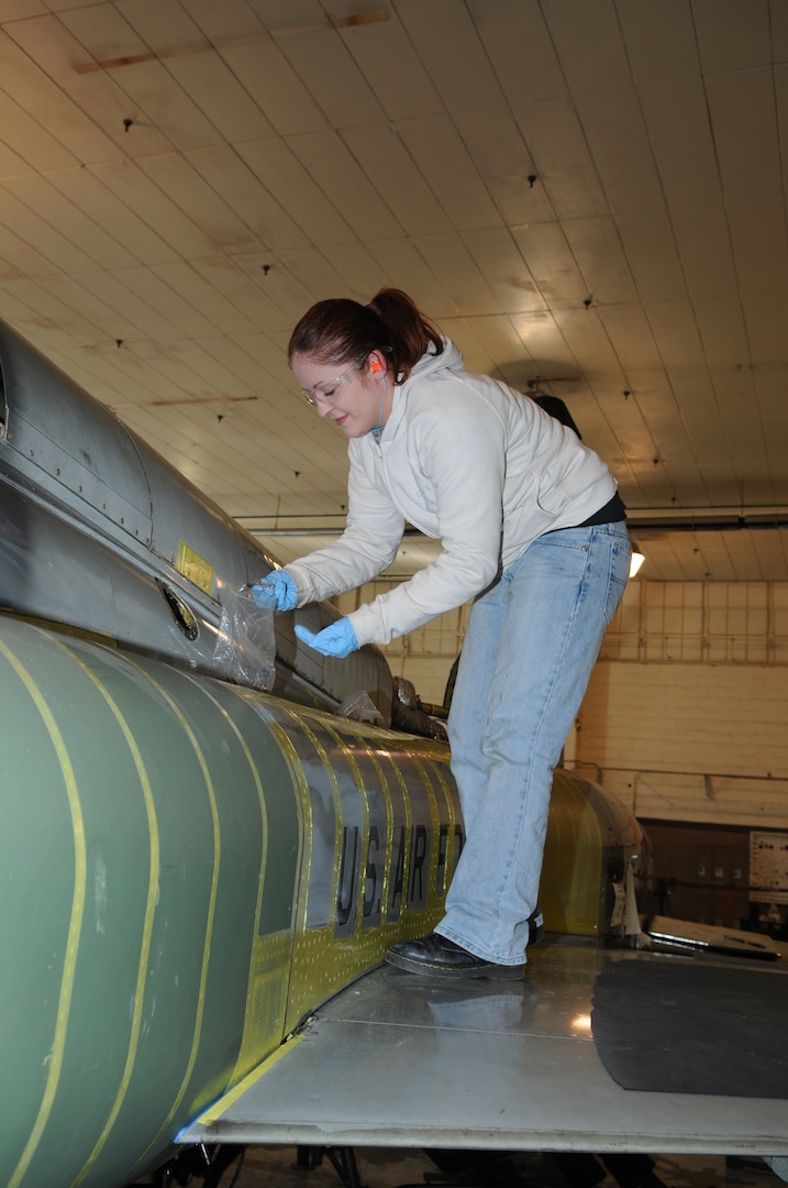 Melanie Dott, Lear Siegler Inc. contractor, performs the final installation of the dorsal fuel cell of a T-38 at the Queen Bee facility at Randolph Air Force Base, TX. Queen Bee is the only heavy maintenance provider for the T-38 fleet, providing support of T-38 inspection, maintenance and modification requirments continuously for more than 30 years. (US Air Force photo by Rich McFadden) 