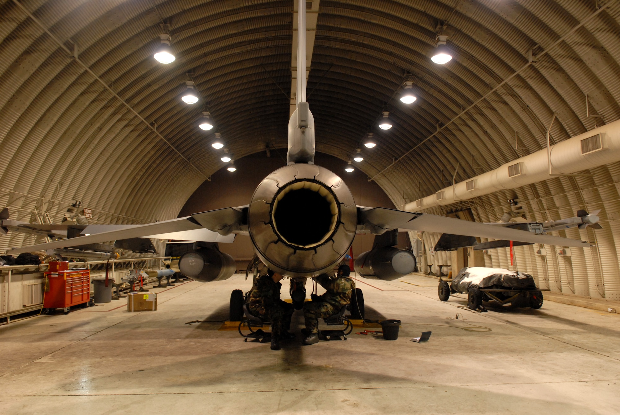 Staff Sgt. Clint Cloonan, 80th Aircraft Maintenance Unit works inside a Hardened Aircraft Shelter with Senior Airman Mark Robinson 80th AMU to remove and replace a control unit on an F-16 during the Peninsula-Wide Operational Readiness Exercise Beverly Bulldog 09-01 at Kunsan Air Base, Republic of Korea, Jan. 13, 2009. The Airmen work inside a HAS to protect them and the aircraft from enemy fire in order to complete the maintenance quickly and safely. (U.S. Air Force Photo by Senior Airman Angela Ruiz)  