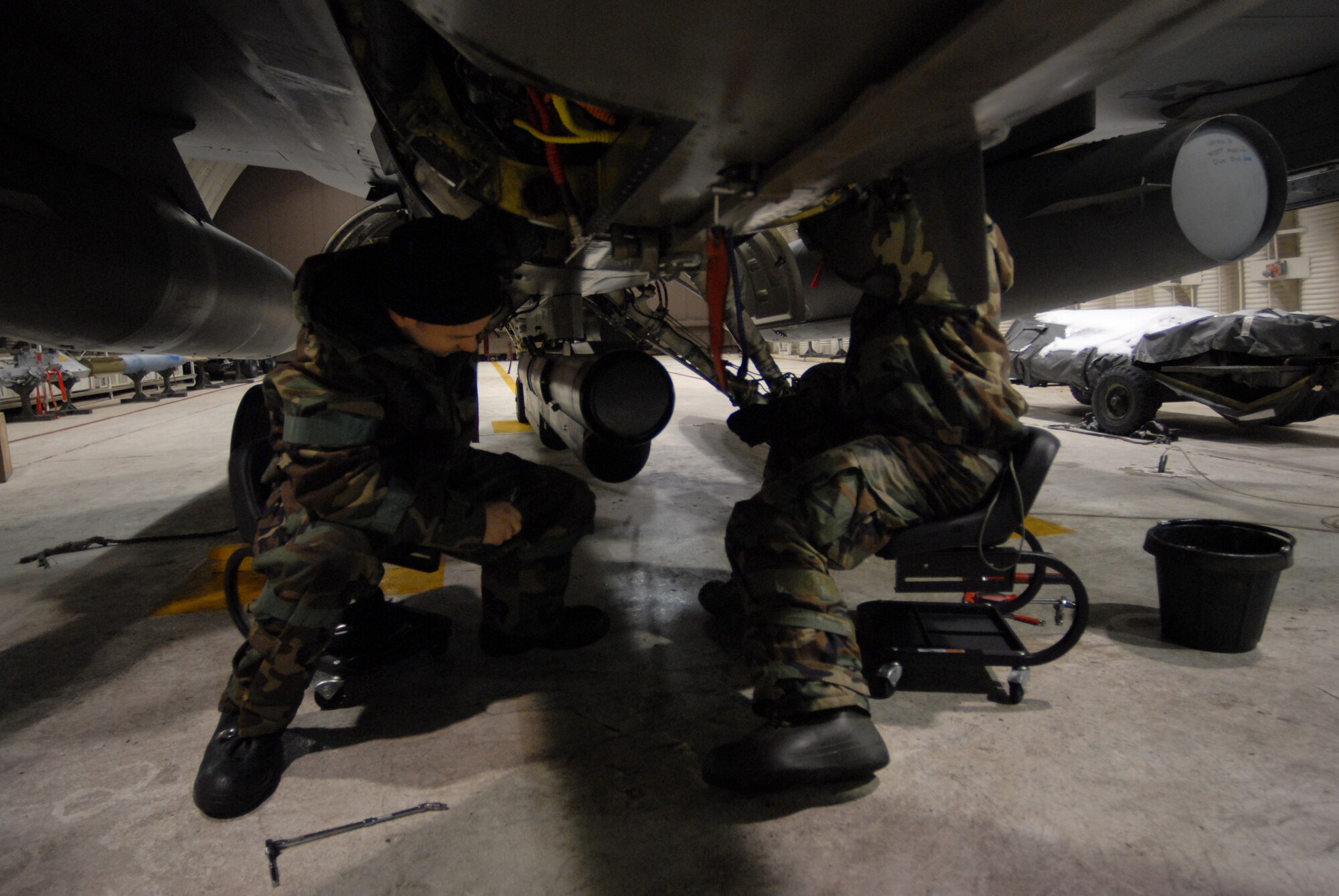 Staff Sgt. Clint Cloonan, 80th Aircraft Maintenance Unit works inside a Hardened Aircraft Shelter with Senior Airman Mark Robinson 80th AMU to remove and replace a control unit on an F-16 during the Peninsula-Wide Operational Readiness Exercise Beverly Bulldog 09-01 at Kunsan Air Base, Republic of Korea, Jan. 13, 2009. The Airmen work inside a HAS to protect them and the aircraft from enemy fire in order to complete the maintenance quickly and safely. (U.S. Air Force Photo by Senior Airman Angela Ruiz)  