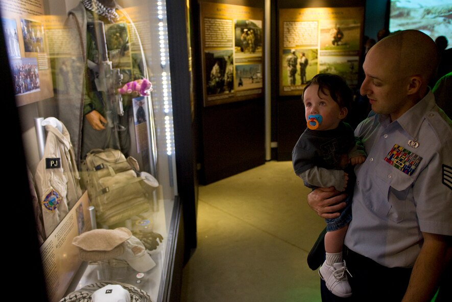 Staff Sgt. Jason Kinney shows his son, Dylan, equipment he used and donated to the Warrior Airmen Exhibit Jan. 12 at the National Museum of the U.S. Air Force at Wright-Patterson Air Force Base, Ohio. Sergeant Kinney is a tactical air control party member who served four tours in Iraq. (Air Force photo by Staff Sgt. Bennie J. Davis III) 