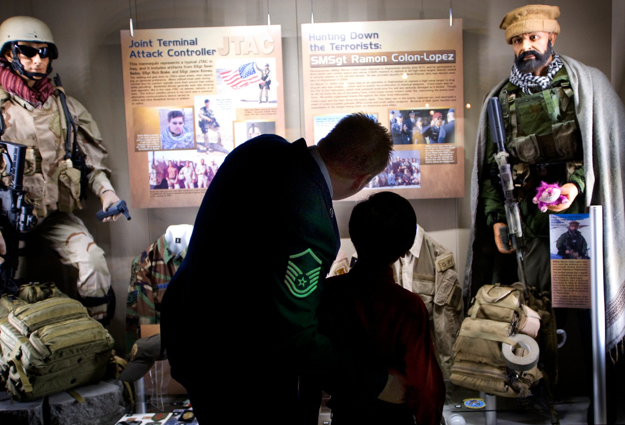 Master Sgt. Keary Miller shows his son, Ian, equipment used by special operations Airmen during the war on terrorism at the opening of the Warrior Airman Exhibit Jan. 12 at the Nation Museum of the U.S. Air Force at Wright-Patterson Air Force Base, Ohio. Sergeant Miller, a pararescuman honored in the Warrior Airmen Exhibit , fought during the Battle of Takur Ghar, the deadliest entanglement of Operation Anaconda in Afghanistan. (U.S. Air Force photo/Staff Sgt. Bennie J. Davis III)