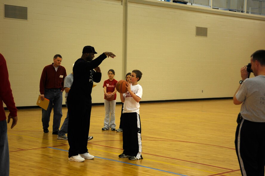 MINOT AIR FORCE BASE, N.D. -- Ronnie Fields, Sky Rockets team member, teaches Greg Sweetland, son of Lt. Col. Mike Sweetland and winner of the 10-year-old boys division, the proper form to shoot a free-throw during a free-throw tournament held at the McAdoo Fitness Center here Jan. 11. The Knights of Columbus Council 8003 sponsored the competition, which was open to all children, ages 10 to 14. The winners of the tournament will compete at the district level and possibly move on to the national competition. (U.S. Air Force photo by Senior Airman Joe Rivera)