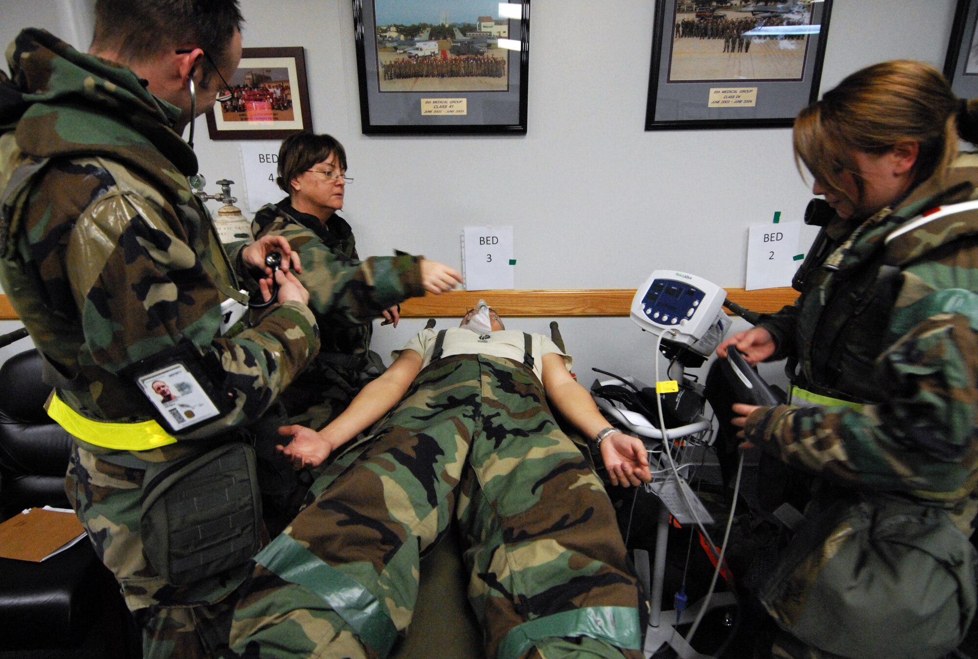 Capts. Kevin Baldovich, Theresa Weber, and Airman 1st Class Sarah Hudak, 8th Medical Group, check the vital signs of a patient during the Peninsula-Wide Operational Readiness Exercise at Kunsan Air Base, Republic of Korea, Jan. 14, 2009. The patient was brought in after experiencing shortness of breath. (U.S. Air Force Photo by Senior Airman Gustavo Gonzalez)