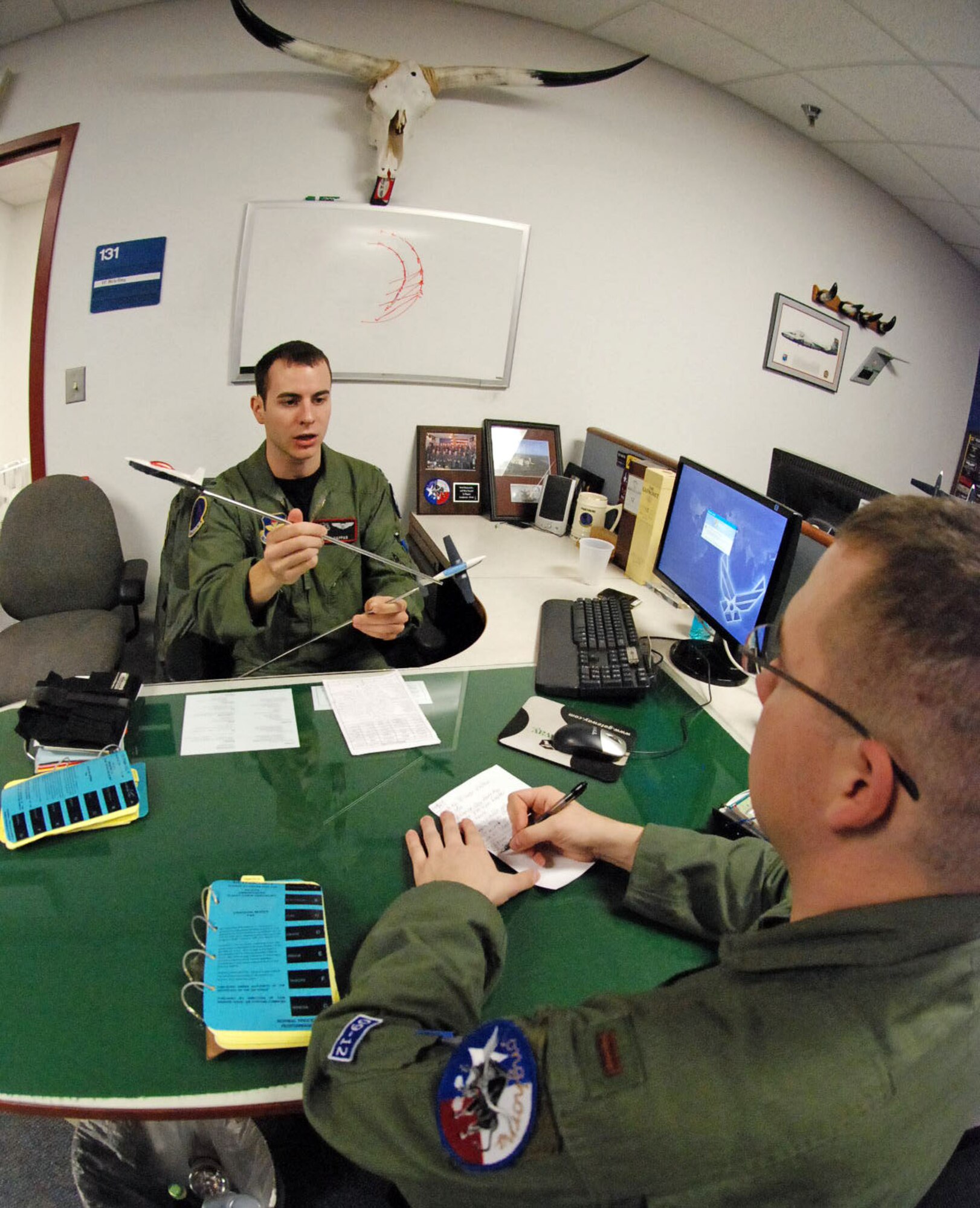 LAUGHLIN AIR FORCE BASE, Texas – First Lt. Paul Pappas, 84th Flying Training Squadron instructor pilot, de-briefs a student from the Longhorn’s flight Class 09-12 after a formation sortie Jan. 12. Laughlin trains more than 300 pilots annually living up to the wing’s motto “America’s airpower starts here.”(U.S. Air Force photo by Airman 1st Class Sara Csurilla)