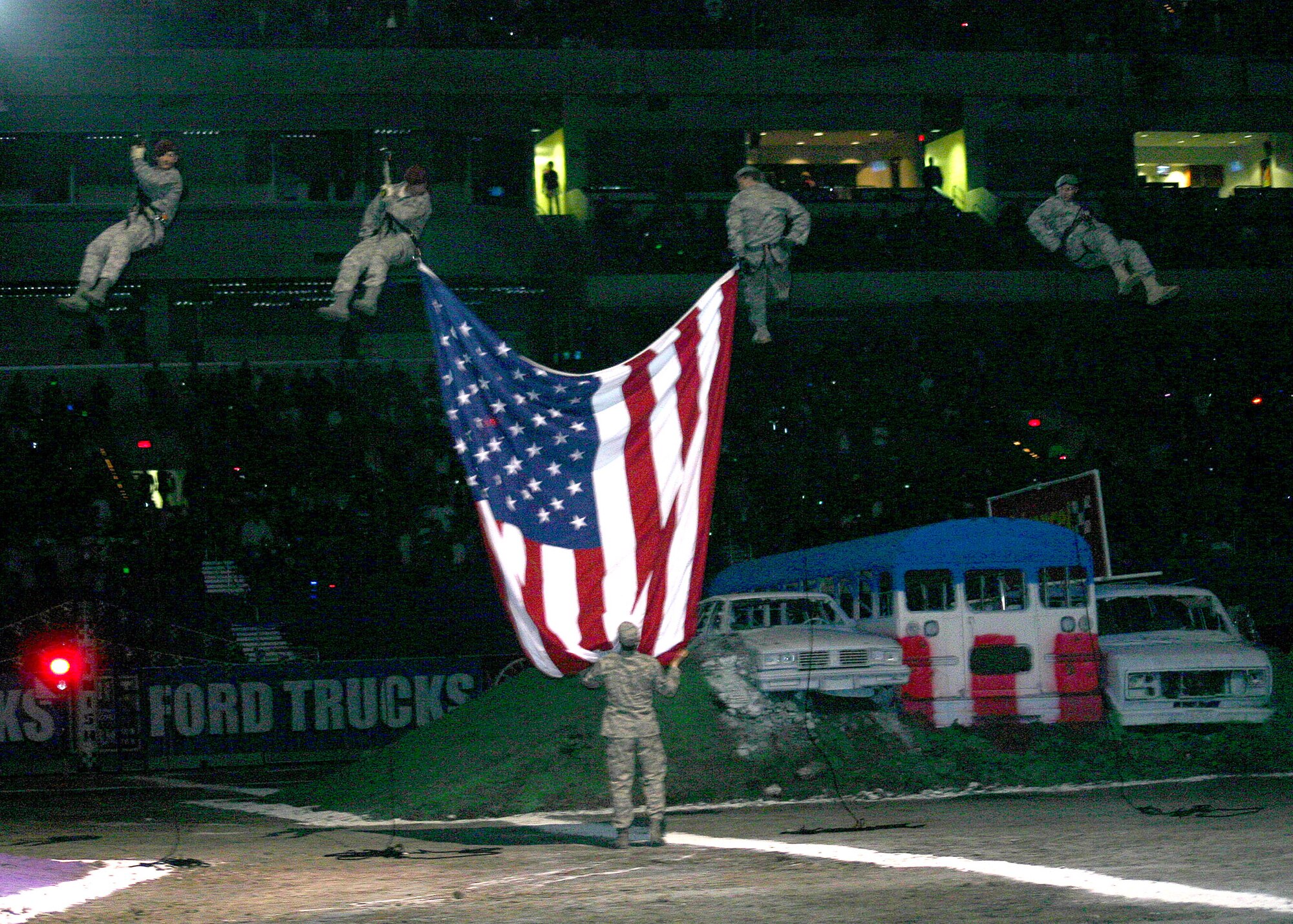 The American flag is unfurled as an Air Force special operations team from nearby Lackland Air Force Base, Texas, rappels from the rafters of the Alamodome Jan. 10 during 2009 Monster Jam in San Antonio. (U.S. Air Force photo/Dale Eckroth)