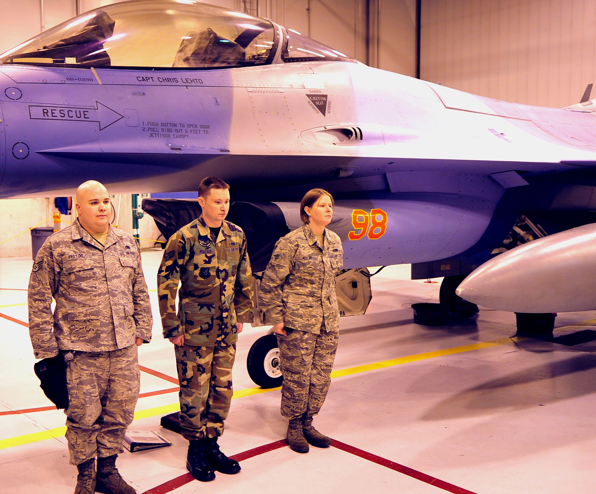 Senior Airman Billy Peacock, Senior Airman Athena Keller, and Staff Sgt. Matthew Fratzke, Weapons Load Team Chief, all 354th Aircraft Maintenance Squadron stand at attention after finishing a load competition. The competition occurs monthly leading up to a high profile load where the best load teams compete. (U.S. Air Force photo/Airman 1st Class Willard E. Grande II)