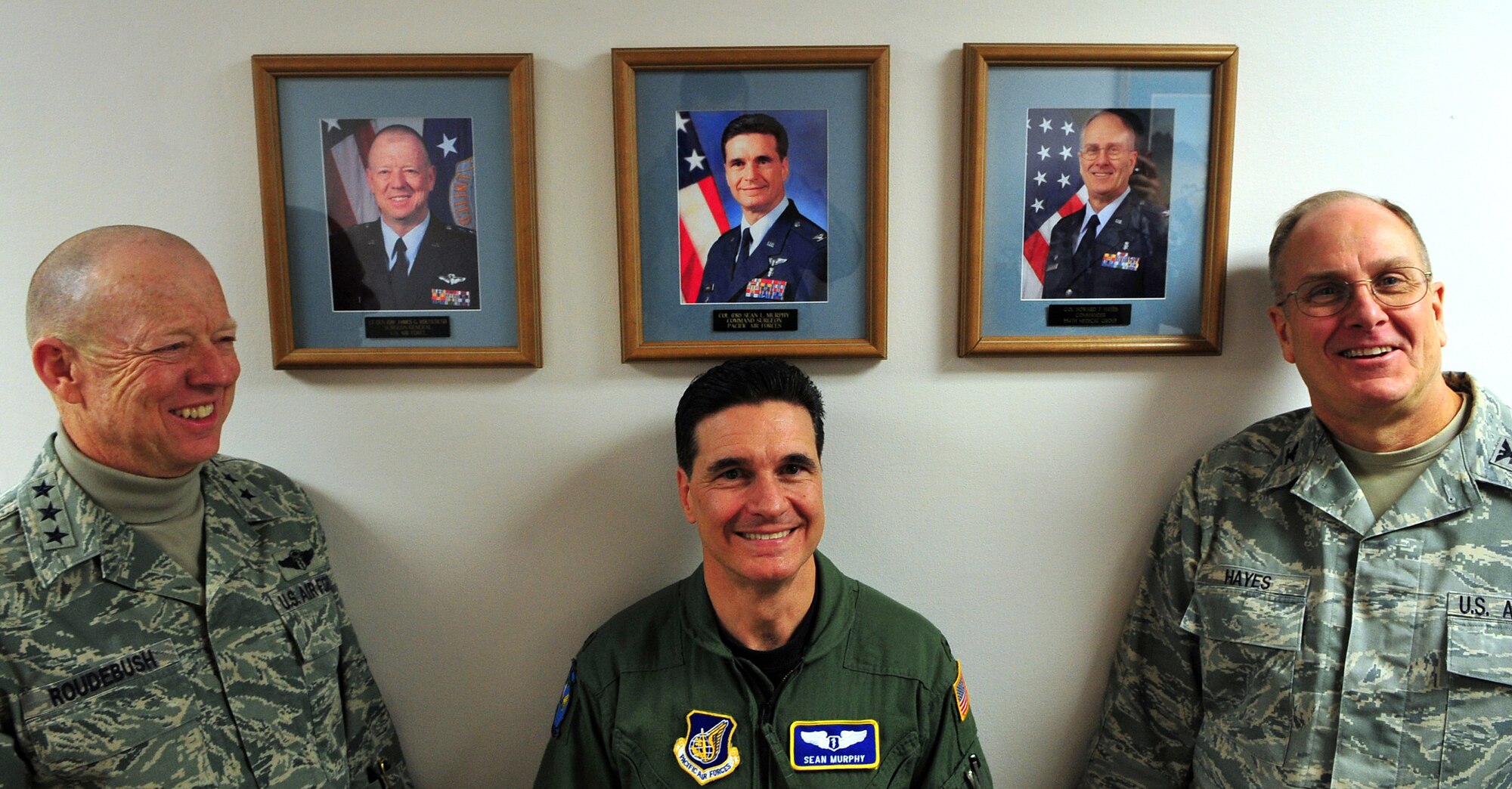 Lt. Gen. James Roudebush, Surgeon General United States Air Force, stands under his photo alongside Col. Sean Murphy, PACAF Surgeon General, and Col. Howard Hayes, Commander 354th Medical Group. Gen. Roudebush was visiting Eielson Air Force Base on a tour of medical facilities throughout the Pacific region. (U.S. Air Force photo/Airman 1st Class Willard E. Grande II)