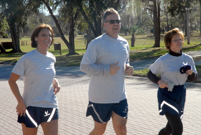 Laci Brokaw, Mike Ivey and Consuella Pockett run a steady pace as they prepare to round the final turn in the Commander's Fitness Challenge 5,000-meter run on base Jan. 9. More than 400 Airmen from various squadrons came out to participate in the  5K run. Ivey is the 437th Airlift Wing command chief, Pockett is the 437th Medical Group commander and Brokaw is the 437th MDG executive officer. (U.S. Air Force photo/Tech. Sgt. Dave Watson)