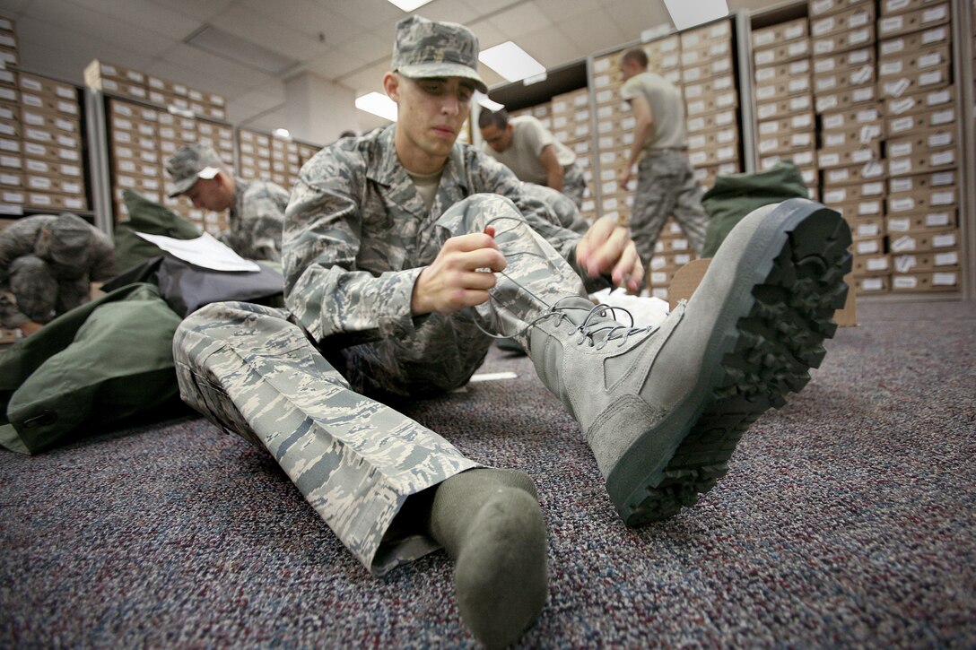 Trainee Kyle Bean laces up the new air battle uniform, or ABU, boots during the first clothing issue Sept. 10 at Lackland Air Force Base, Texas. He is in the first flight to receive the ABU boot in basic military training. (U.S. Air Force photo/Robbin Cresswell) 