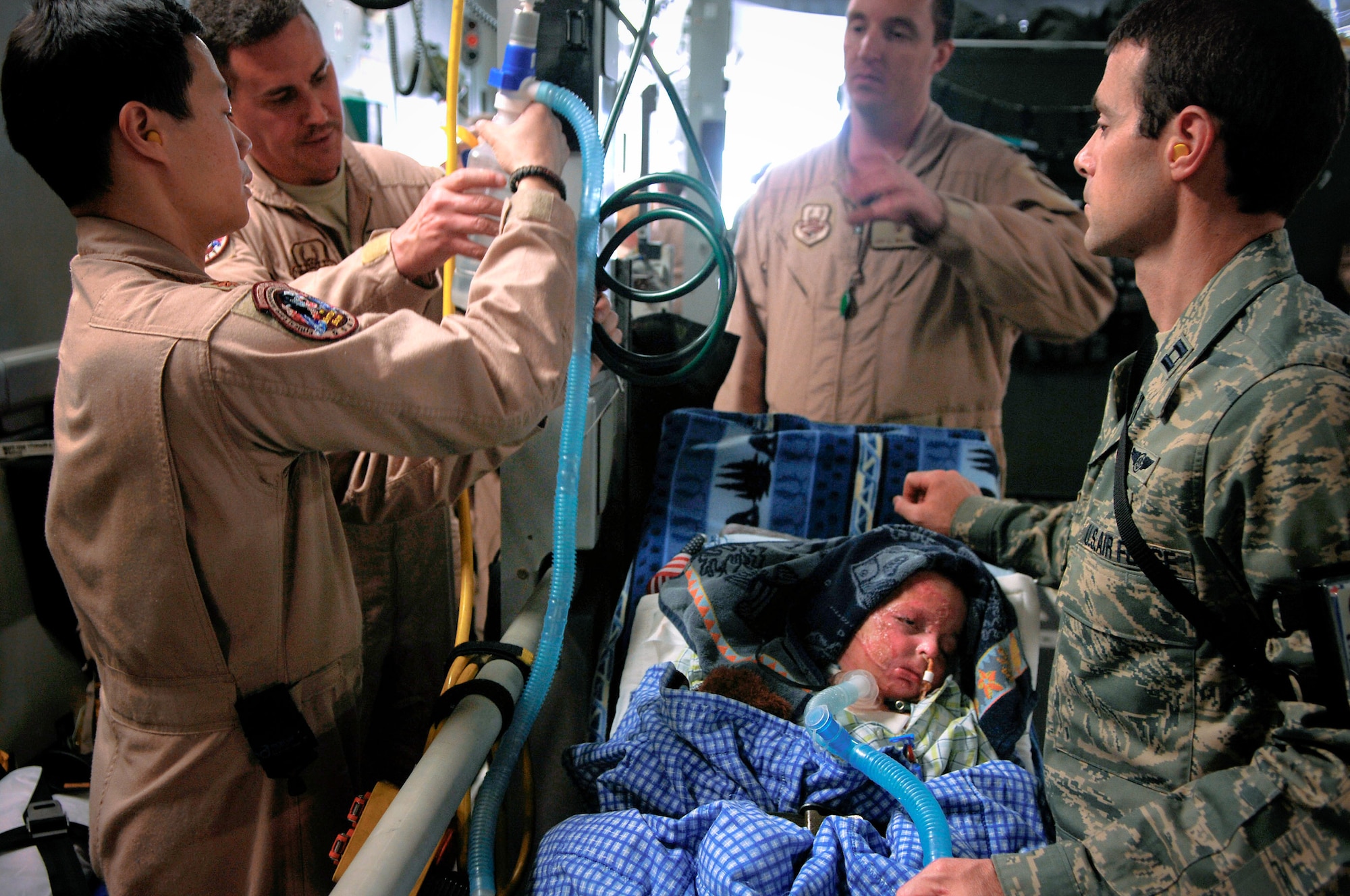 Members of the 332nd Expeditionary Aeromedical Evacuation Flight's Critical Care Transportation Team prepare Al Amreeki, a 3-year-old Iraqi burn victim, for a flight to the United States March 21. The Shriners Hospitals for Children-Cincinnati will provide ongoing treatment and rehabilitation. (U.S. Air Force photo/Tech. Sgt. Jeffrey Allen)
