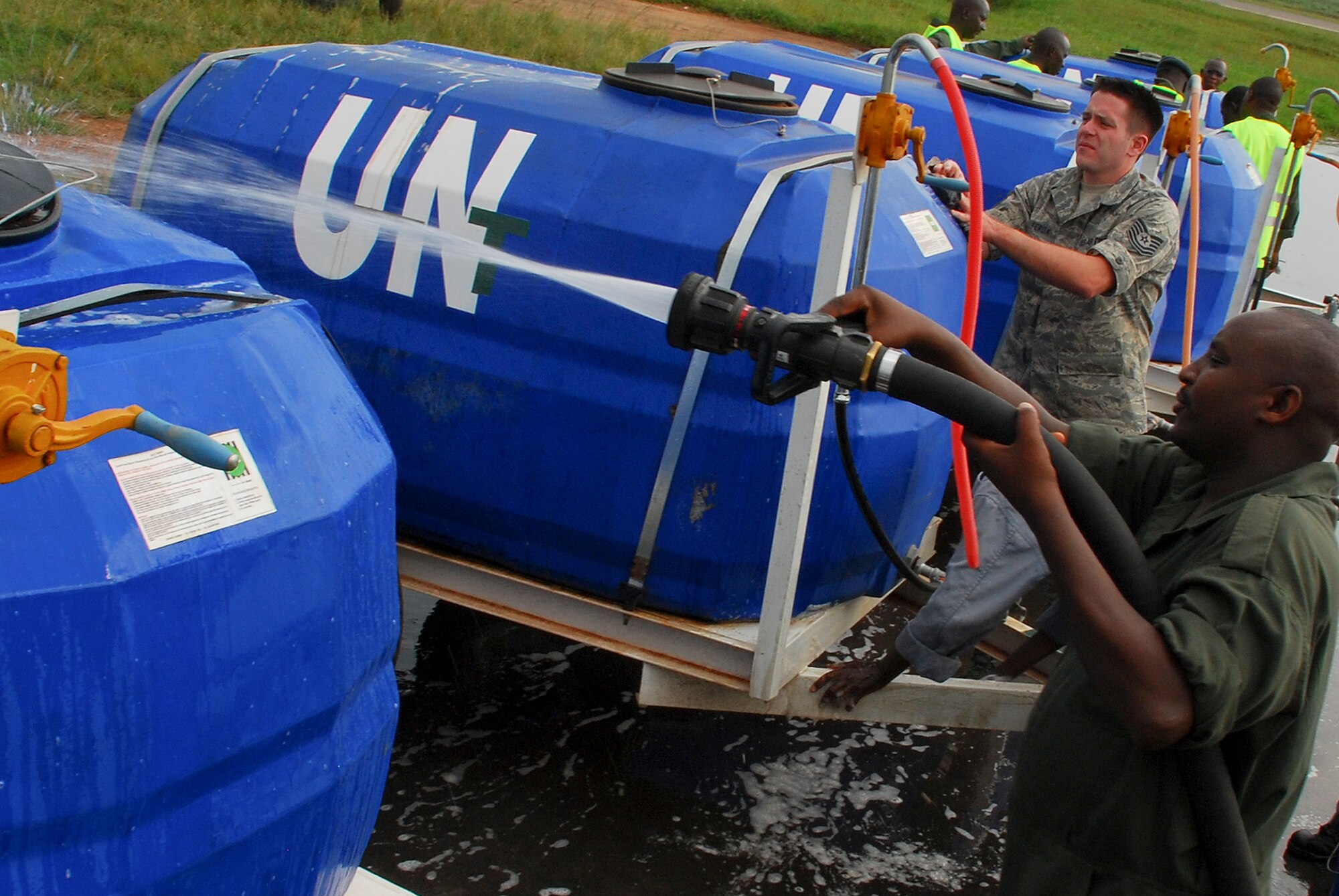 KIGALI, Rwanda - Tech.Sgt. Bradley Ferda from the 722nd Expeditionary Airbase Squadron, 17th Air Force, U.S. Africa Command, joins volunteers from the Kigali Fire Department and Rwandan Defense Forces soldiers to wash water tanks and other military vehicles in preparation for their deployment to the Darfur region of Sudan as part of the United Nations-Africa Union Peacekeeping mission there. The vehicles will be transported via U.S. Air Force C-17 Globemaster III cargo planes.
(Photo by Staff Sgt. Samuel Bendet, U.S. Africa Command)
