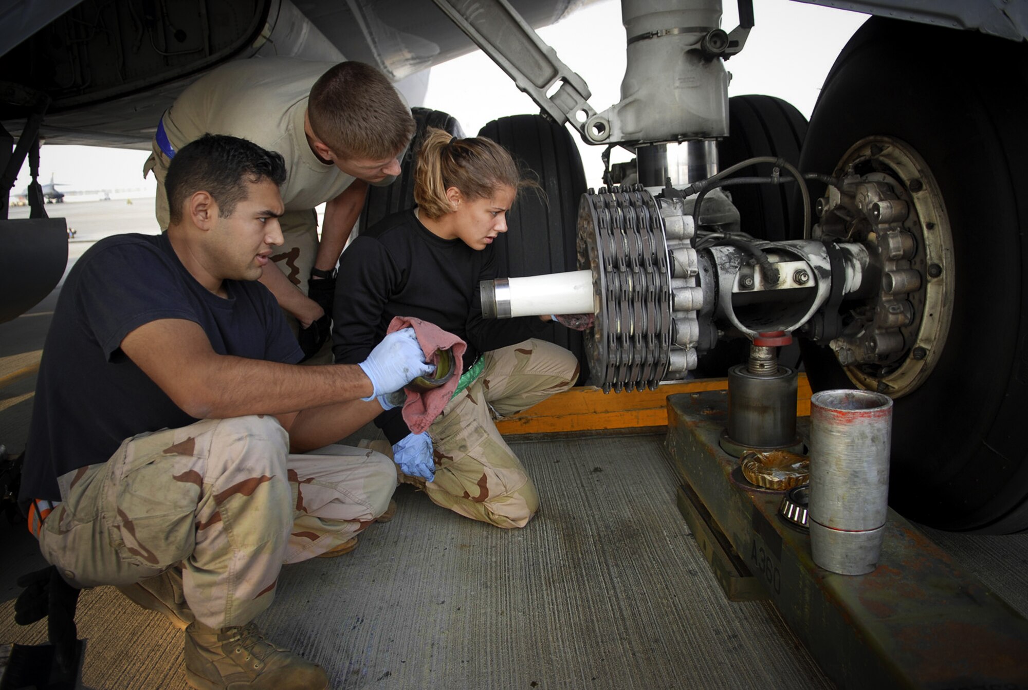 At a Southwest Asia air base Jan. 5., Staff Sgts. Ruben Mariscal (left) and Frank Veres with Airman 1st Class Abigail Smith prepare to install a new wheel on a KC-135 Stratotanker. They are assigned to the 379th Expeditionary Aircraft Maintenance Squadron. (U. S. Air Force photo/Staff Sgt. Douglas Olsen)