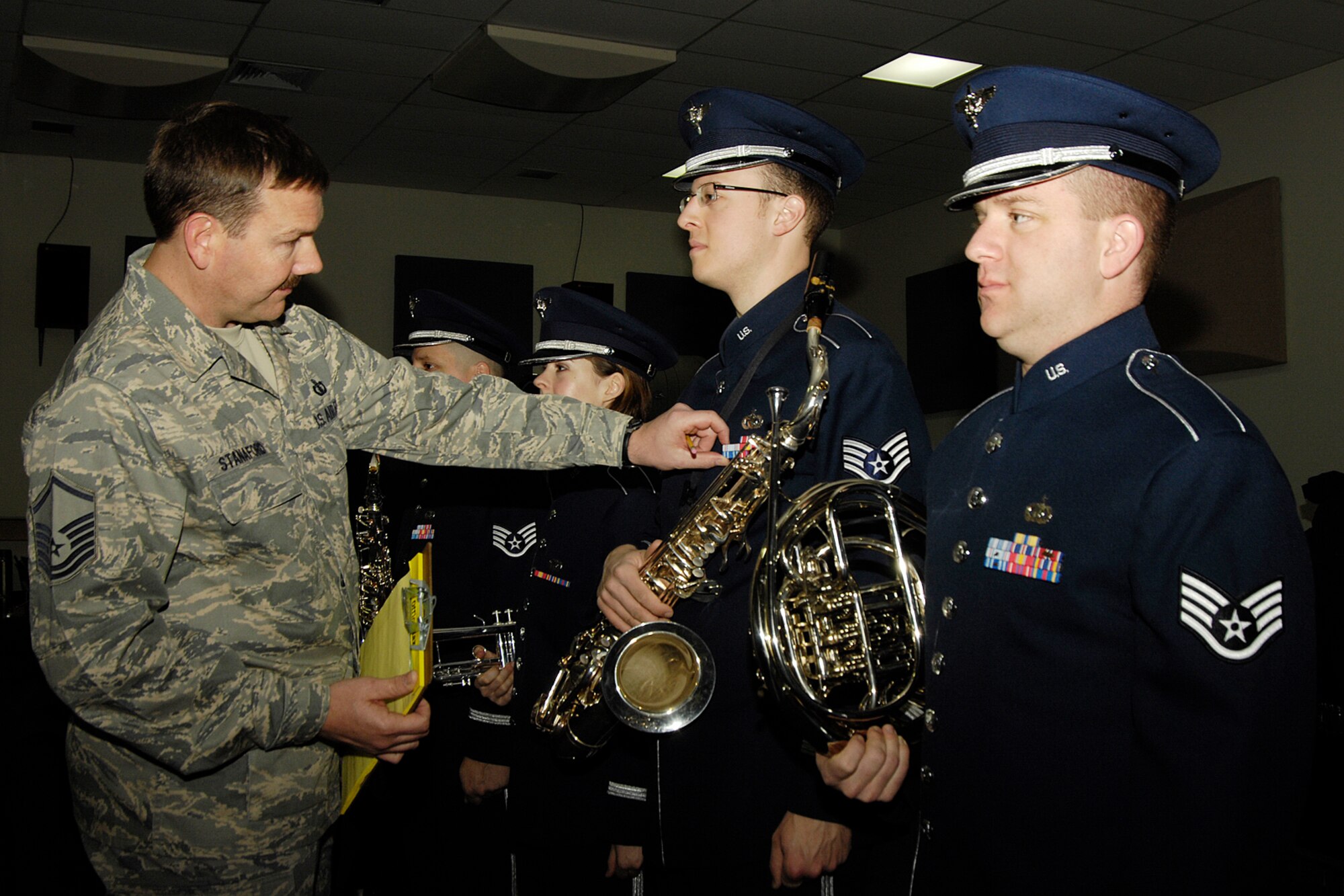 HANSCOM AIR FORCE BASE, Mass. – Master Sgt. Mark Stanaford (left), U.S. Air Force Band of Liberty, inspects the uniform of saxophonist Staff Sgt. Anthony Balester, while French horn player Staff Sgt. Andy Fordham stands at attention. Members of the Ceremonial Band were inspected in preparation for their trip to Washington to perform final honors for President George W. Bush at Andrews AFB on Jan. 20, when he makes his final departure on Air Force One following Inauguration ceremonies. (U.S. Air Force photo by Linda LaBonte Britt)
