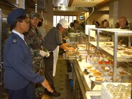 Senior Airman Deandrea Dorsey, 919th Services Flight food services specialist, listens as Master Sgt. Renae Houey, a Hennessy Award Program inspector from Headquarters Air Force Reserve Command, inquires about serving line activities in the base dining facility Sunday. The program's inspectors examine every aspect of a services unit's food services operation. The command-level winner of the John L. Hennessy trophy is expected to be announced in about a month.
