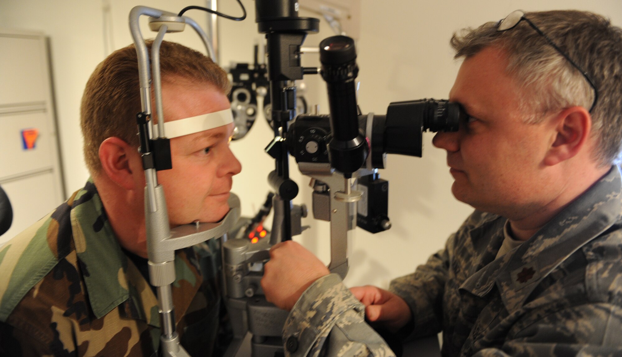 WHITEMAN AIR FORCE BASE, Mo. - Maj. Doug Franz, 509th Medical Operations Squadron optometrist, operates a slit lamp bio-microscope to check a patient’s eye health Jan. 12. A slit lamp allows the doctor to spot any ulcers, cornea abrasions or other diseases that may be located in the cornea. The device shines a pin hole light into the surface of the eye as the doctor looks through the scope. The optometry clinic serves active duty and dependents and is open Monday – Thursday from 7:30 a.m. – 4:30 p.m. and Friday from 8:30 a.m. – 4:30 p.m. Appointments can be made by calling 687-2188. (U.S. Air Force photo/Airman 1st Class Carlin Leslie)