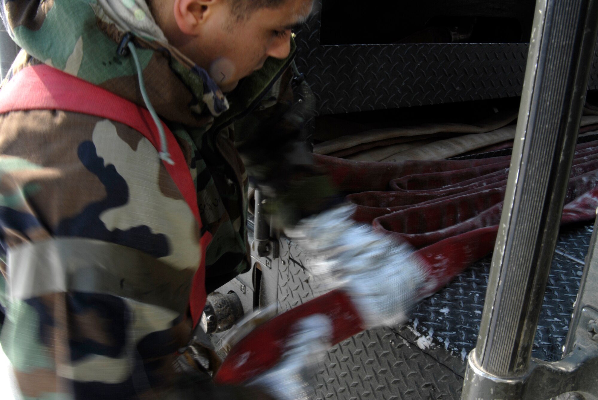 Senior Airman Alex Vasquez, 8th Civil Engineer Squadron Fire Department, rerolls a fire hose after a simulated fire during the Peninsula Wide Operation Readiness Exercise at Kunsan Air Base, Republic of Korea, Jan. 13, 2009.(U.S. Air Force Photo by SSgt Jason Colbert)