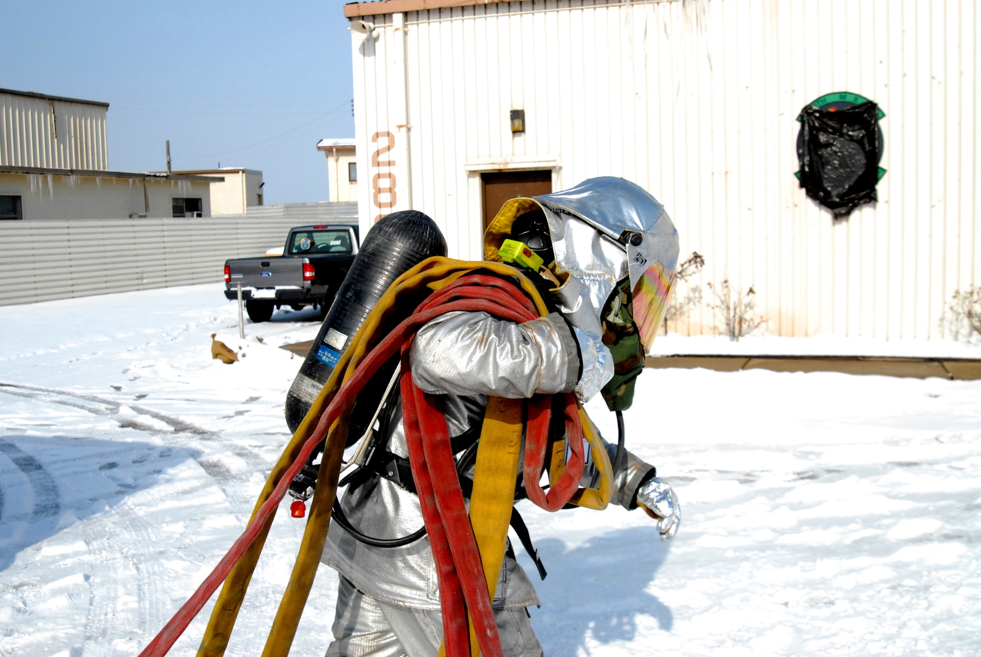 A member of the 8th Civil Engineer Squadron Fire Department rushes to a fire carrying a bundle of fire hoses during the Peninsula Wide Operation Readiness Exercise at Kunsan Air Base, Republic of Korea, Jan. 13, 2009. (U.S. Air Force Photo by SSgt Jason Colbert)