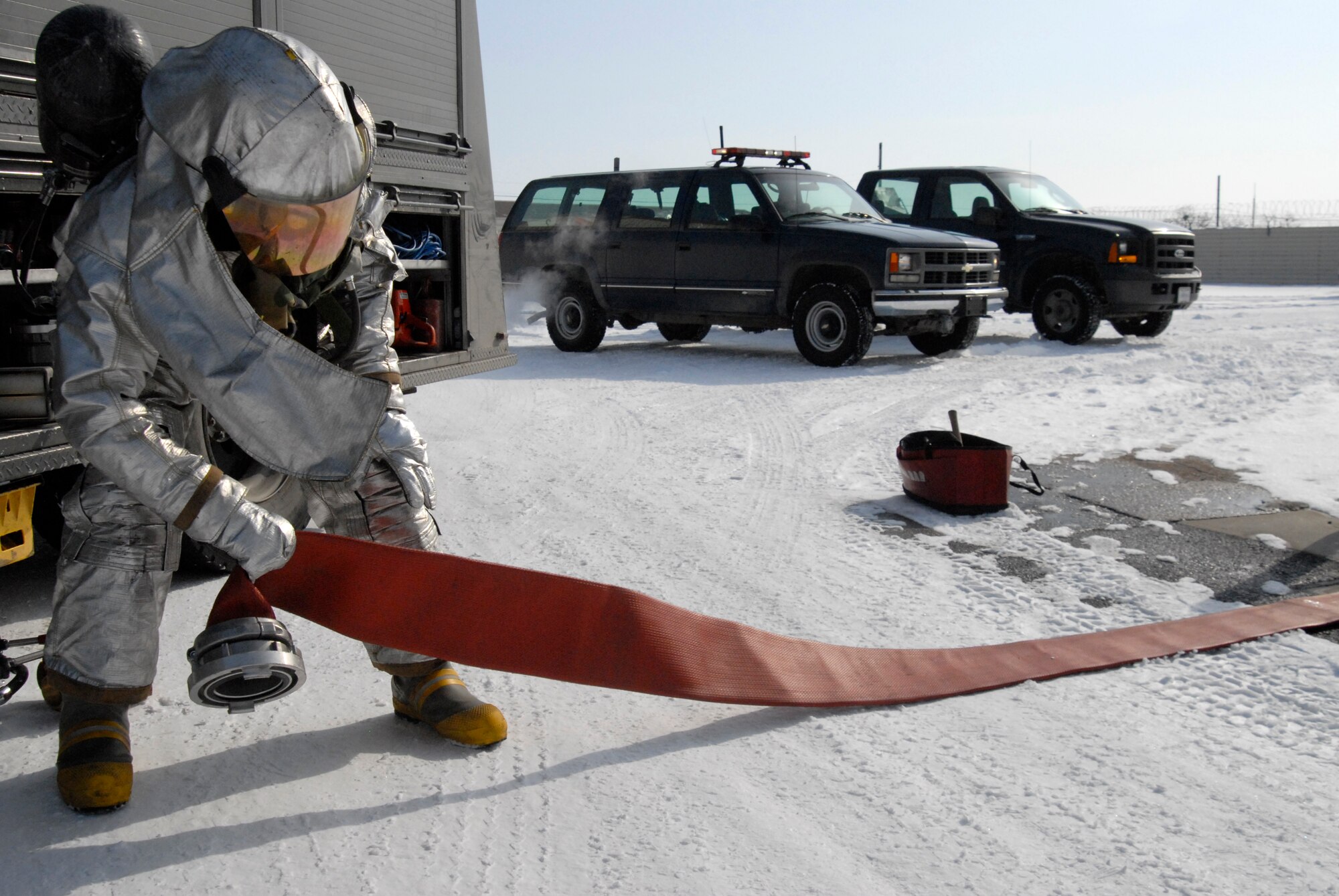Senior Airman Alex Vasquez, 8th Civil Engineer Squadron Fire Department, unrolls a fire hose at a simulated fire during the Peninsula Wide Operation Readiness Exercise at Kunsan Air Base, Republic of Korea, Jan. 13, 2009. Kunsan's Fire Fighters have seven minutes from the time they are dispatched to respond to an incident. (U.S. Air Force Photo by SSgt Jason Colbert)
