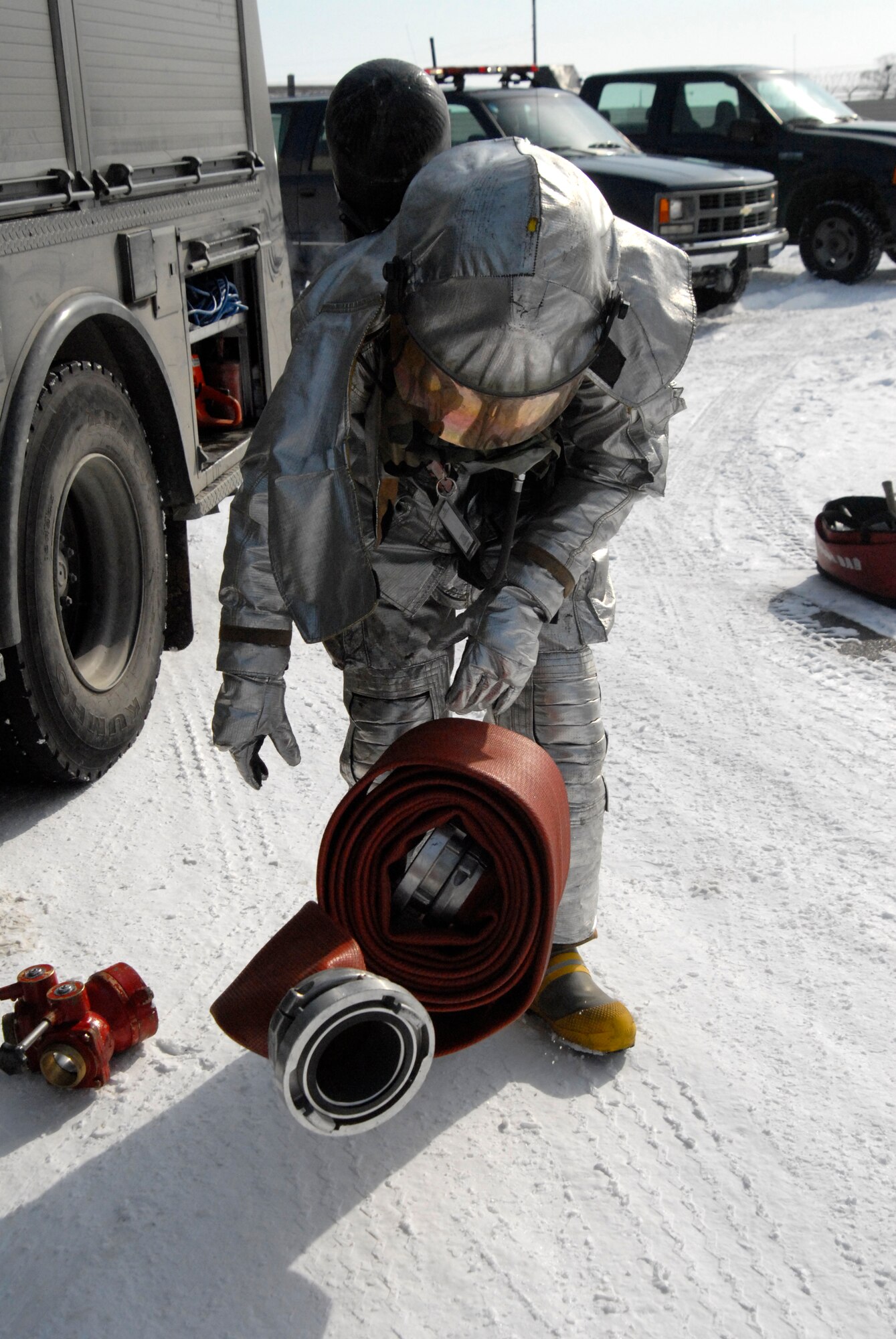 Senior Airman Alex Vasquez, 8th Civil Engineer Squadron Fire Department, unrolls a fire hose at a simulated fire during the Peninsula Wide Operation Readiness Exercise at Kunsan Air Base, Republic of Korea, Jan. 13, 2009. Kunsan's Fire Fighters have seven minutes from the time they are dispatched to respond to an incident. (U.S. Air Force Photo by SSgt Jason Colbert)