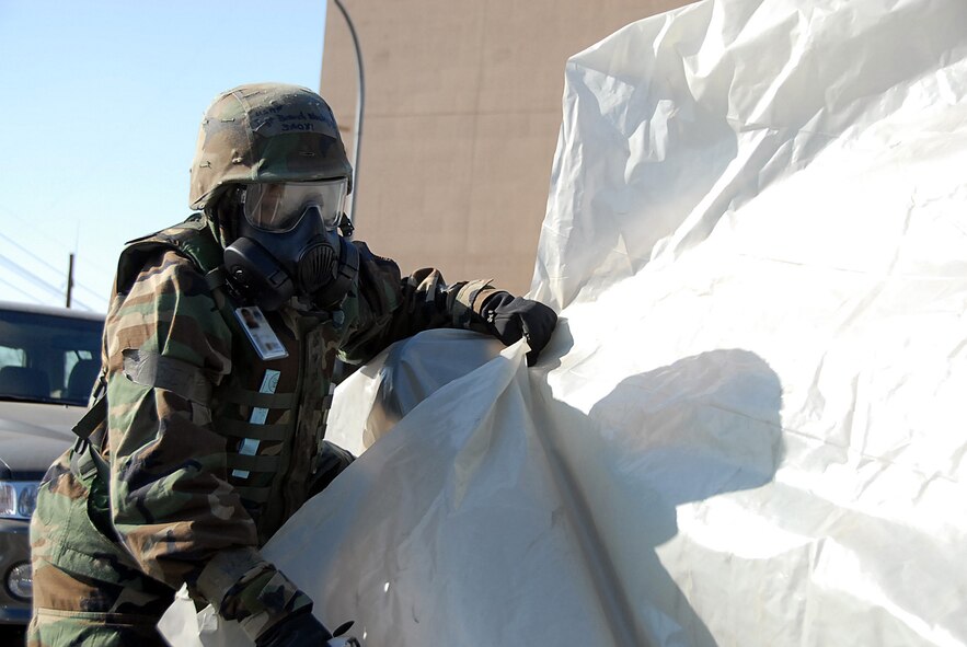 Staff Sgt. Brandi Washington re-positions a second layer of protection over a government vehicle in front of 51st Fighter Wing headquarters building Jan. 13 as part of Exercise Beverly Bulldog 09-01. Assets are covered with two layers of protection to help prevent contamination in a chemical environment. Sergeant Washington is assigned to the 51st Fighter Wing Mission Support Group. (U.S. Air Force photo/Master Sgt. Paul Kilgallon) 
