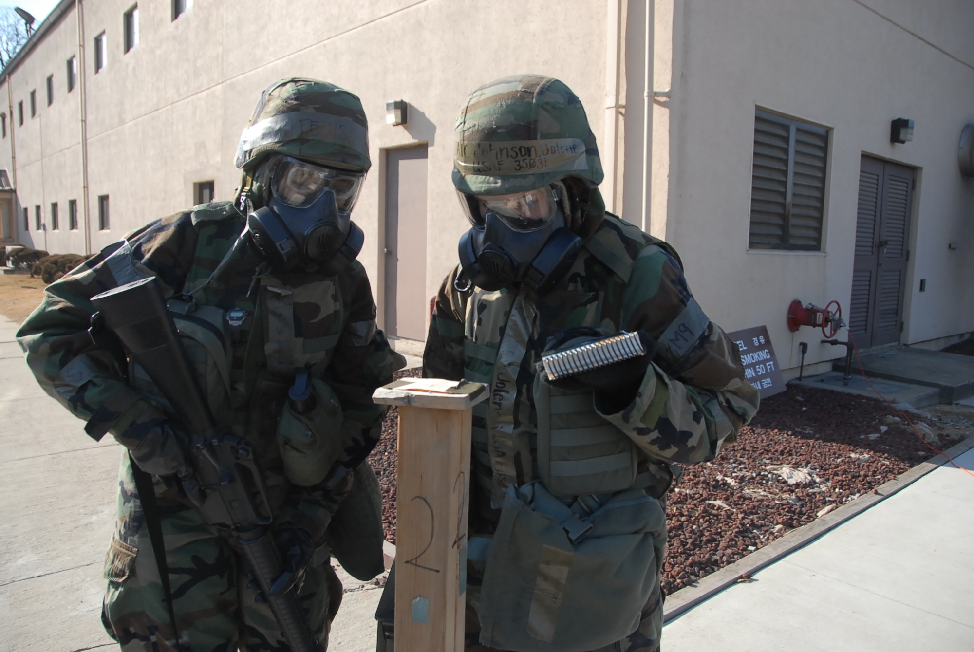 Airmen 1st Class Lakisha White (left) and Jolene Johnson examine a chemical an M-8 detection stand for signs of contamination shortly after a simulated ground burst attack Jan. 13 during Exercise Beverly Bulldog 09-01. The detection stands provide forces a simple, rapid method of detecting chemical warfare agents. Both Airman White and Johnson are assigned to the 51st Mission Support Squadron. (U.S. Air Force photo/Master Sgt. Paul Kilgallon)