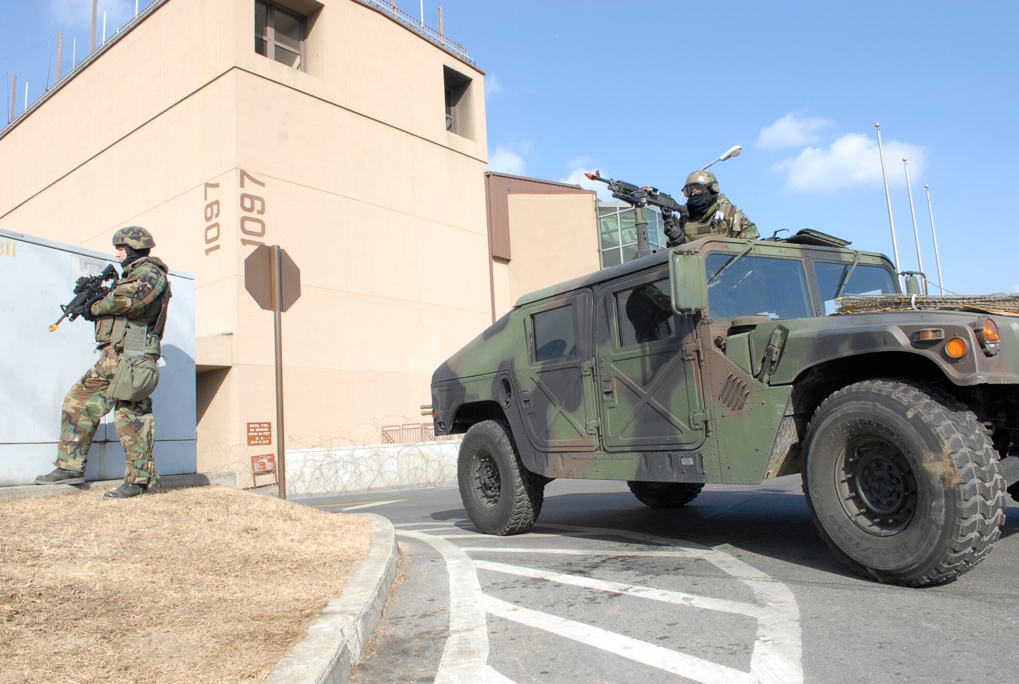 Airman 1st Class Corey Lockhart (left) secures the perimeter of the Installation Control Center as the occupants perform a "bug-out" drill Jan. 12 during exercise Beverly Bulldog 09-01. Security Forces Airman help protect personnel as they transfer from one secure location to another. "Bug-out" drills are performed to demonstrate the effectiveness of building occupants to evacuate from a building as quickly and safely as possible. The 51st Fighter Wing is currently undergoing an Operational Readiness Exercise to test its ability to conduct war time missions. Airman Lockhart is assigned to the 51st Security Forces Squadron. (U.S. Air Force photo/Staff Sgt. Scottie T. McCord) 