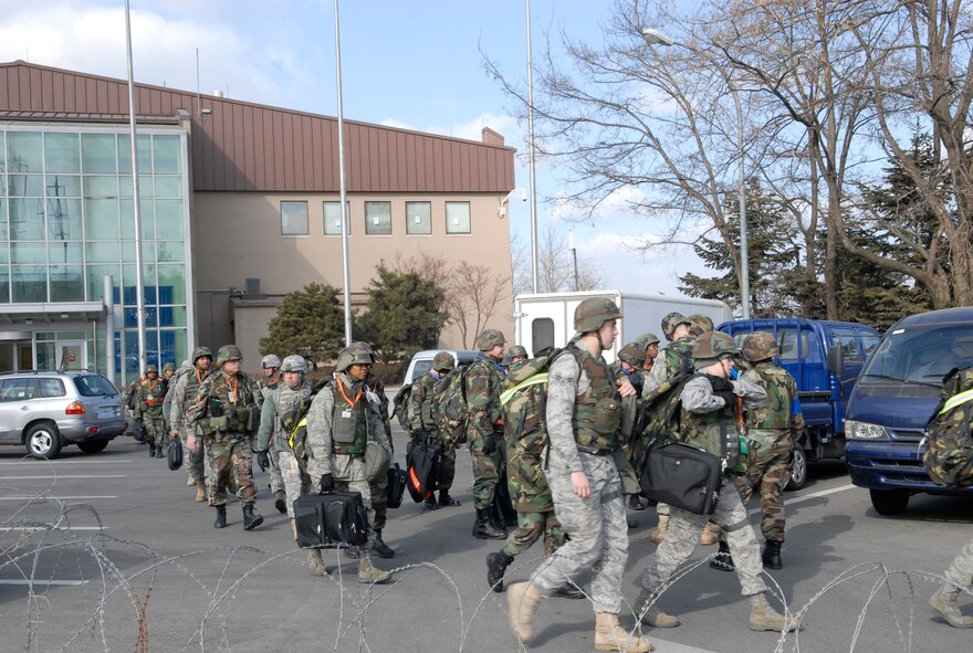 Airmen from the 51st Fighter Wing Emergency Operations center and the Installation Control Center perform a "bug-out" drill during exercise Beverly Bulldog 09-01 Jan. 12. "Bug-out" drills are performed to demonstrate the effectiveness of building occupants to evacuate from a building as quickly and safely as possible. The 51st Fighter Wing is currently undergoing an Operational Readiness Exercise to test its ability to conduct war time missions. (U.S. Air Force photo/Staff Sgt. Scottie T. McCord)