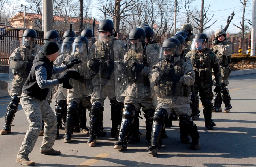 A protestor taunts members of the 51st Security Forces Squadron Jan. 12 during exercise Beverly Bulldog 09-01 at the Osan AB main gate.  Security Forces Airmen are trained to use the minimum force necessary to protect Air Force installations, personnel and resources. The 51st Fighter Wing is currently undergoing a week-long Operational Readiness Exercise to test its ability to conduct war time missions (U.S. Air Force photo/Staff Sgt. Scottie T. McCord)