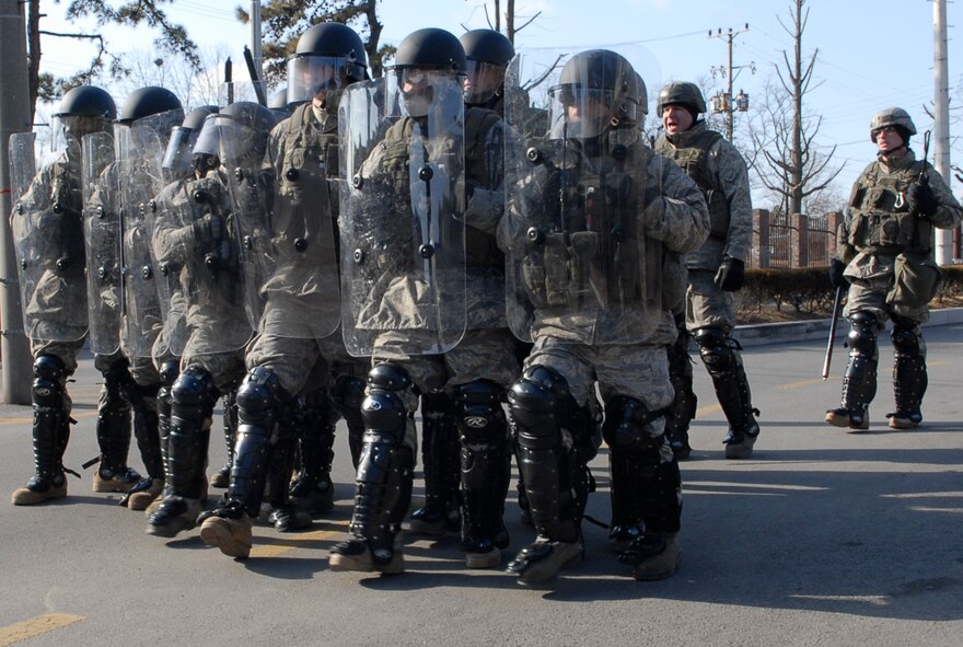 Airmen from the 51st Security Forces Squadron, form a security line as a demonstration of force to prevent simulated protestors from entering the main gate at Osan AB Jan. 12 during Exercise Beverly Bulldog 09-01. Security Forces Airmen are trained to use the appropriate means necessary to protect Air Force installations, personnel and resources. The 51st Fighter Wing is currently undergoing a week-long Operational Readiness Exercise to test its ability to conduct war time missions. (U.S. Air Force photo/Staff Sgt. Scottie T. McCord)