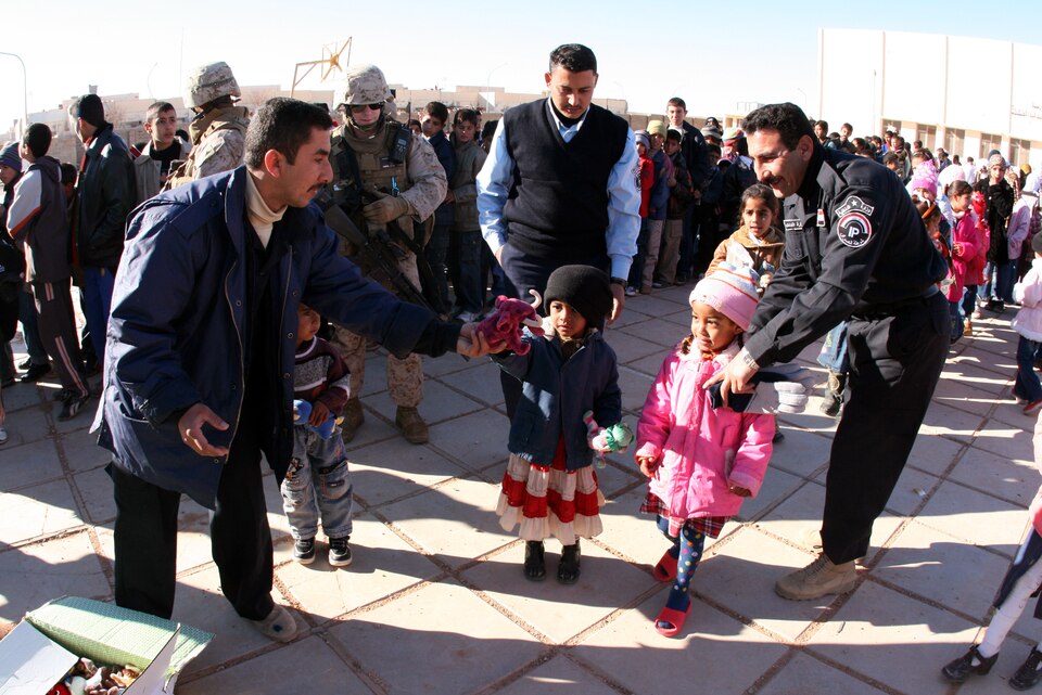 Iraqi police officers distribute toys to children at Akashat Primary School on the outer fringes of Iraq’s western al-Anbar province Jan. 14.