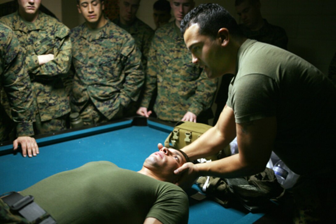 Petty Officer 2nd Class Ariel Ampier (right), a hospital corpsman with 2nd Battalion, 9th Marine Regiment, demonstrates the proper way to care for a wounded Marine here Jan. 12 as part of the combat life-savers course.  The Danbury, Conn., native taught Marines from 3rd Bn, 9th Marines a variety of life-saving skills to treat burns, broken bones and bullet wounds. (Official U.S. Marine Corps photo by Lance Cpl. Brian M. Woodruff) (RELEASED)
