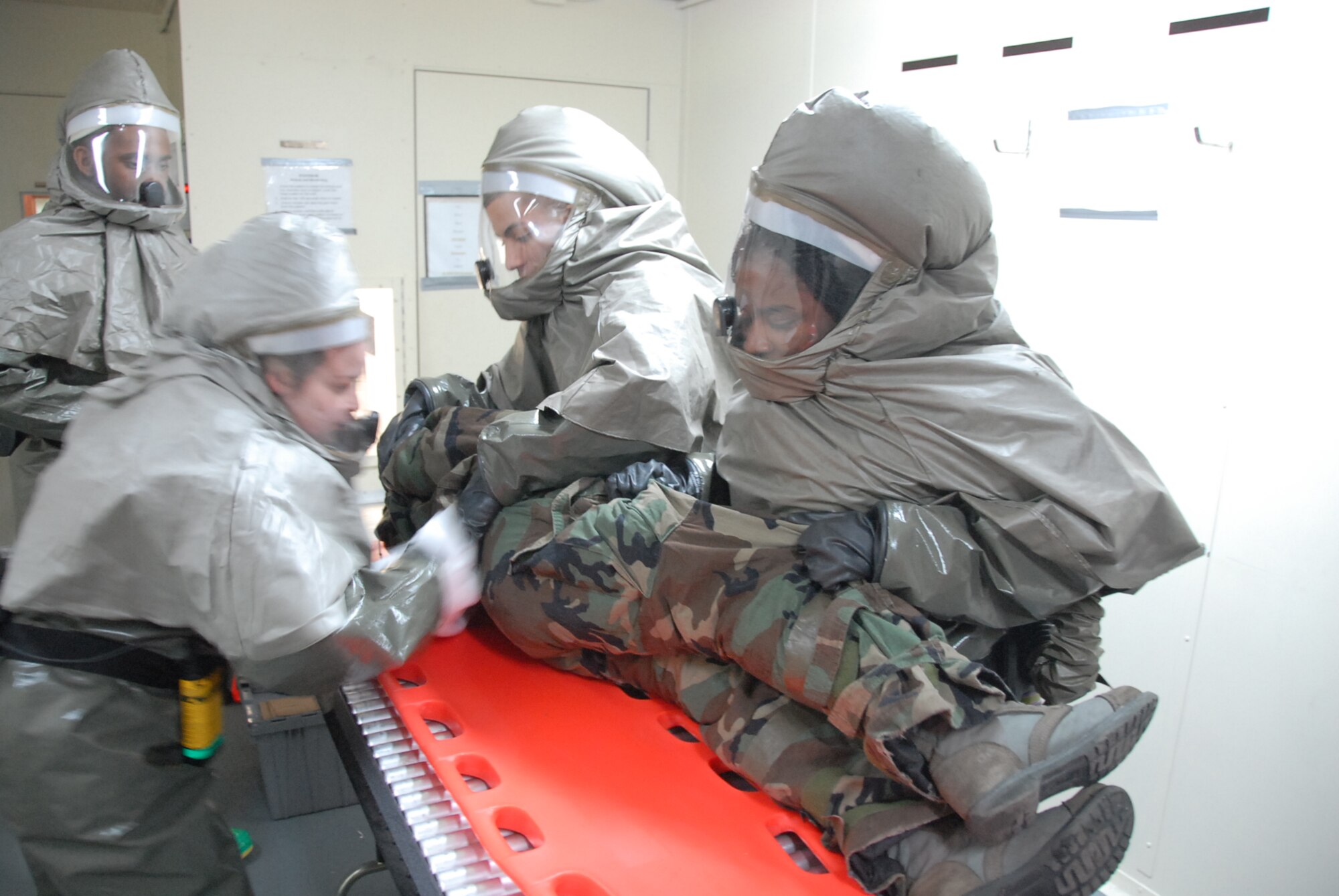 Staff Sgt. Shaunelle Roberts (right), and SrA Michael Maldonado (center), hold an exercise patient on his side while additional medical staff simulate decontaminating the patient during Exercise Beverly Bulldog 09-01 on Osan AB Jan. 14. Sergeant Roberts and Airman Maldonado are both assigned to the 51st Medical Group on Osan AB. (U.S. Air Force photo/Master Sgt. Paul Kilgallon)