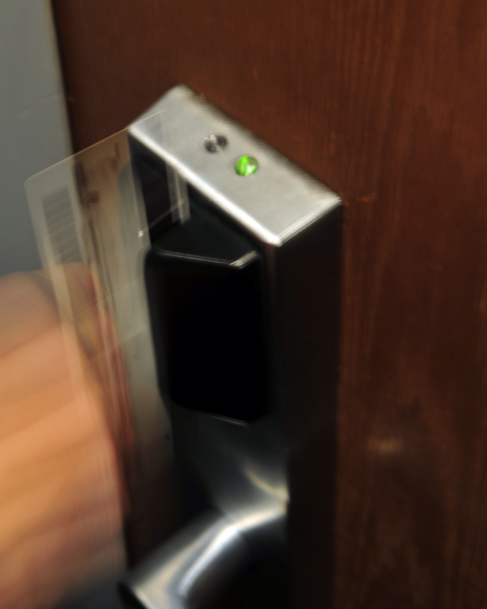 An Airman swipes his card through the dormitories new card swipe system to unlock his dormitory room. The new system can tell who has swiped their card and when it was swiped as a new security measure. (U.S. Air force photo/Airman 1st Class Willard E. Grande II)